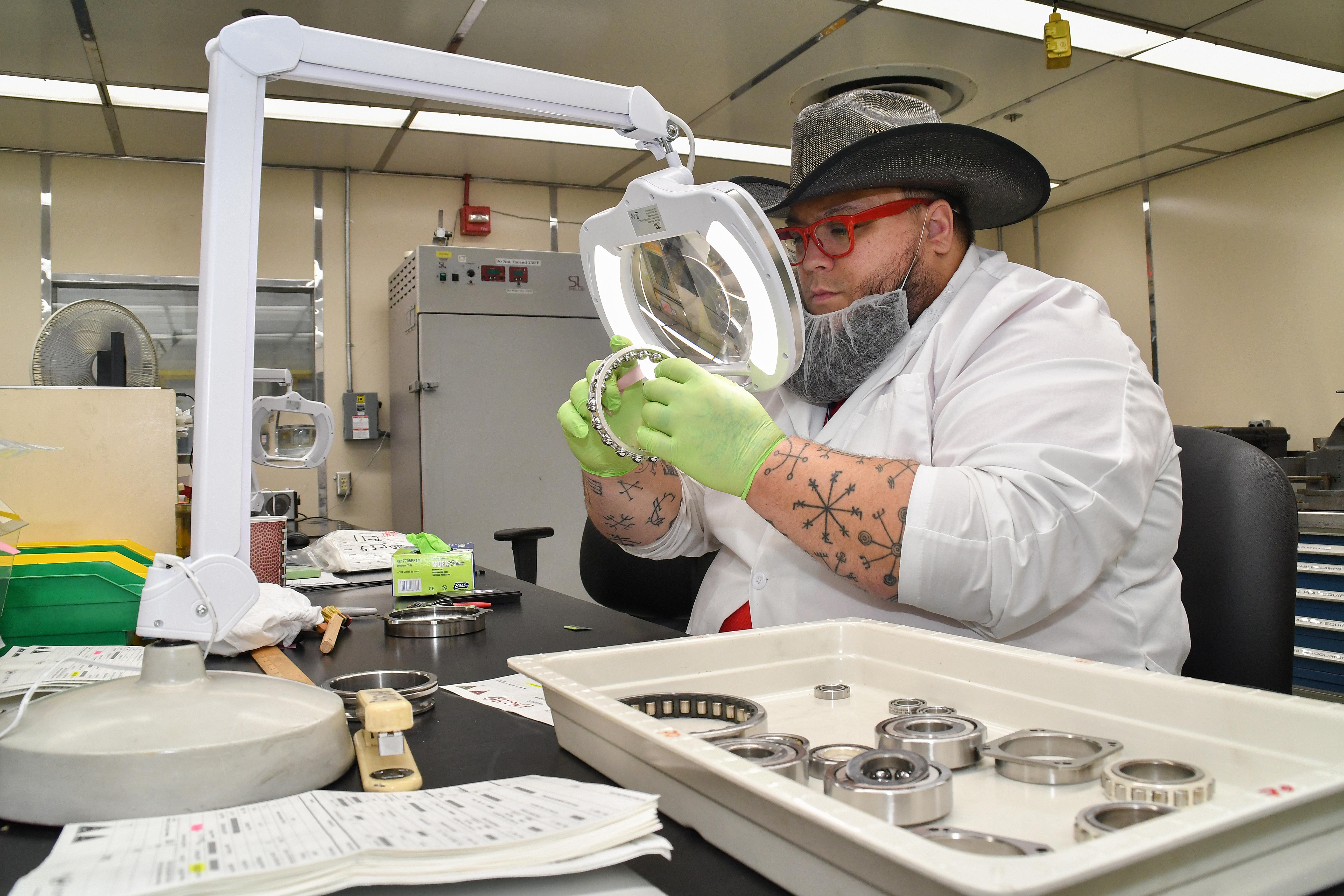 Chad Bogdahn, a bearing reconditioner at Fleet Readiness Center East (FRCE), inspects a bearing inside the depot’s bearing shop. FRCE’s Bearing Shop refurbishes hundreds of bearings each week, turning out several thousand each month. 