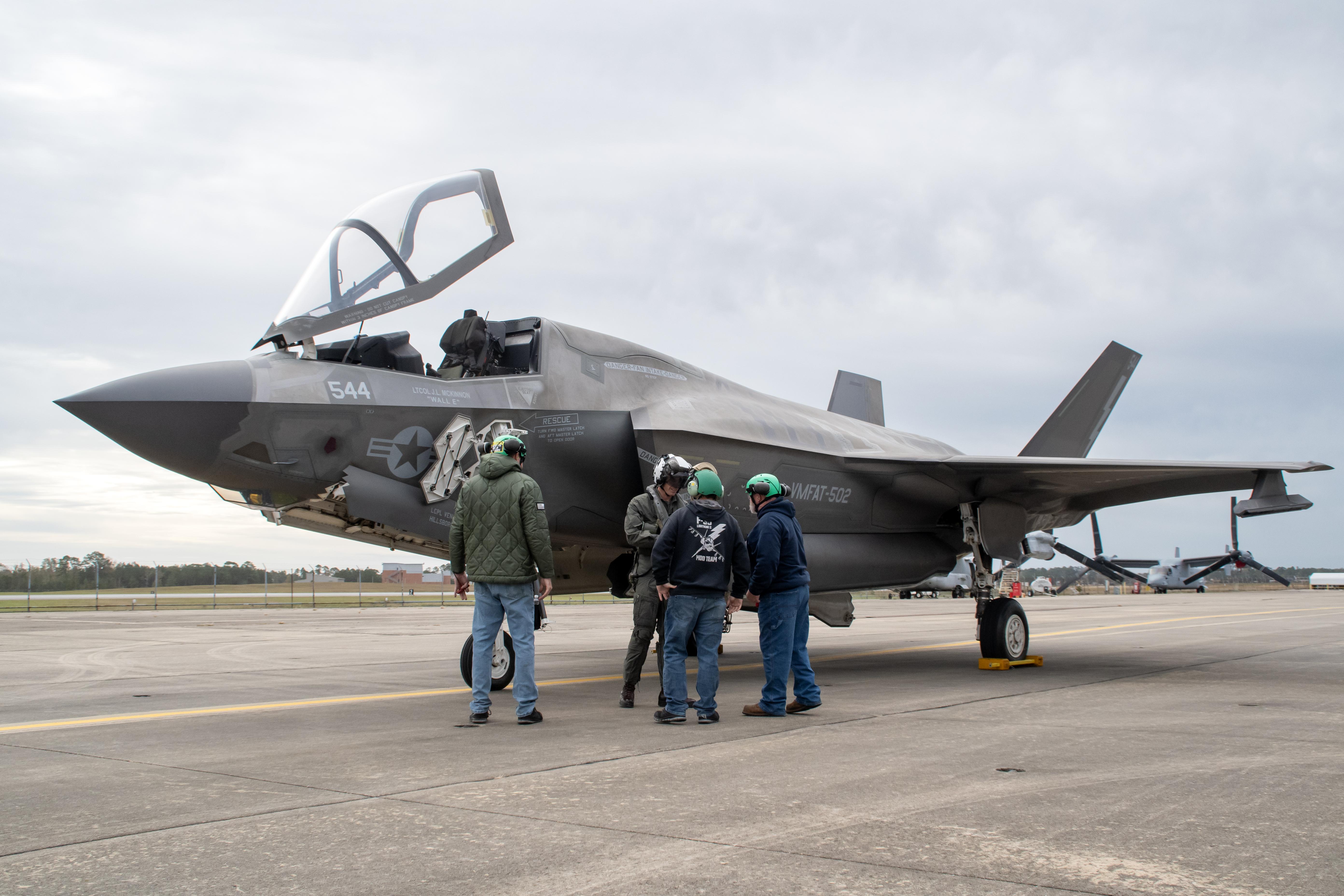 Workers on the Fleet Readiness Center East (FRCE) F-35 Lightning II aircraft modification line confer with the pilot prior to conducting a functional check flight inspection on an F-35B at Marine Corps Air Station Cherry Point. This aircraft is the 150th fifth-generation fighter inducted by the depot. 