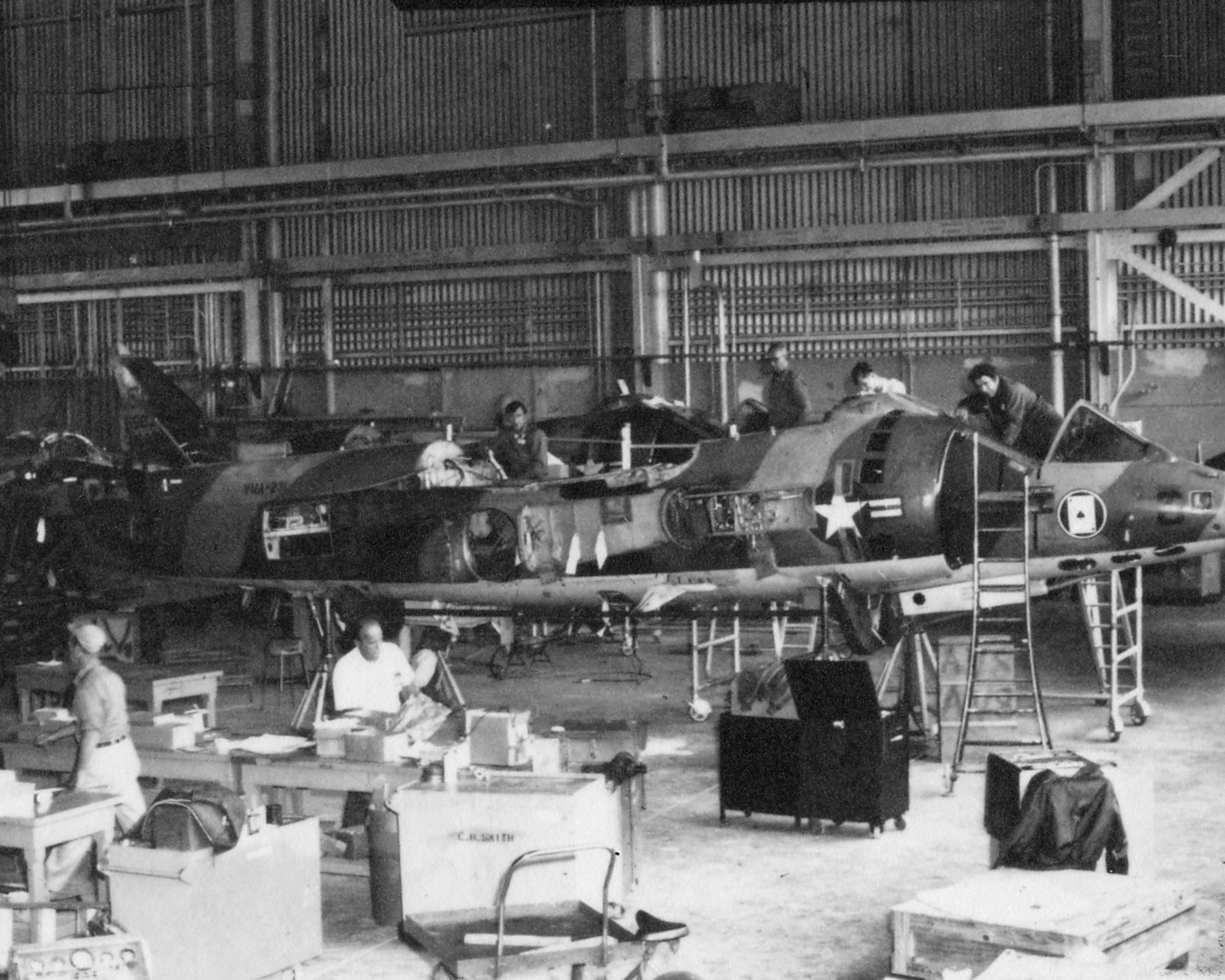 black and white photo of artisans working on old AV-8 Harrier aircraft