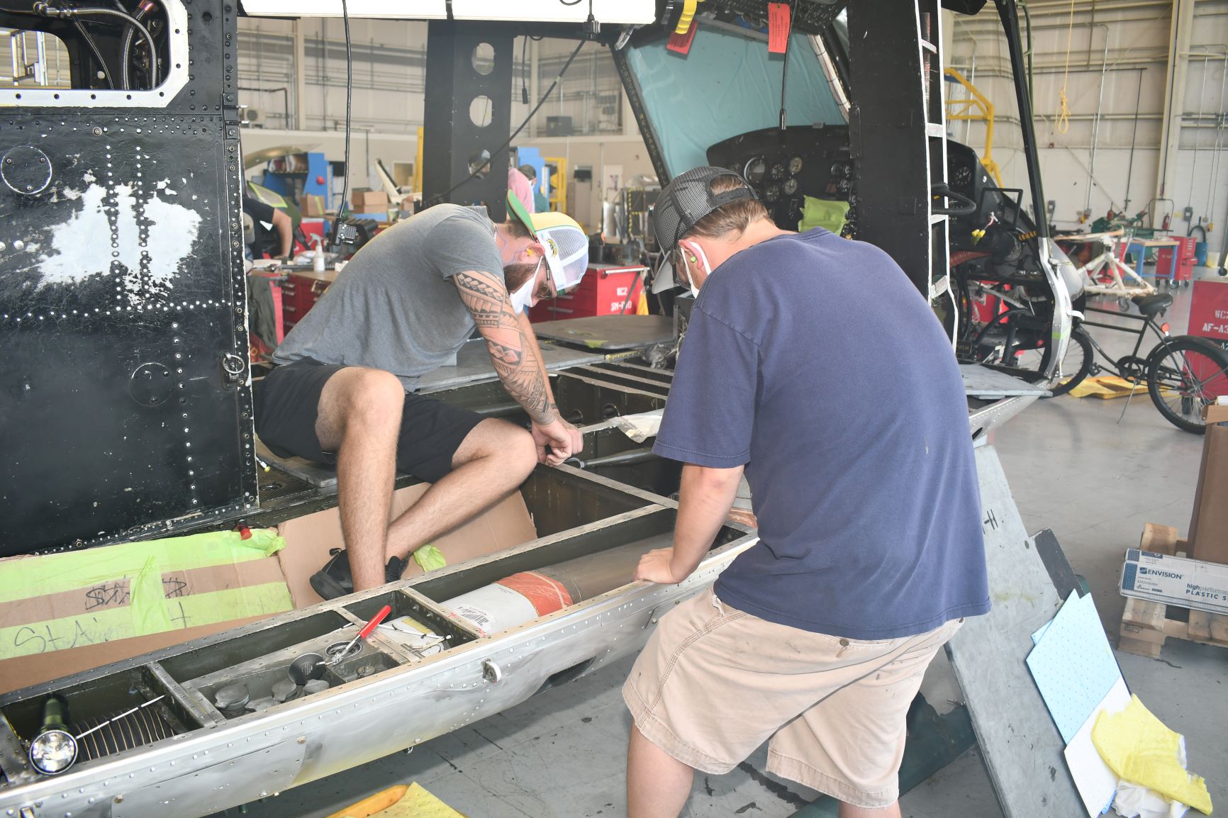 Men work on H-1 helicopter