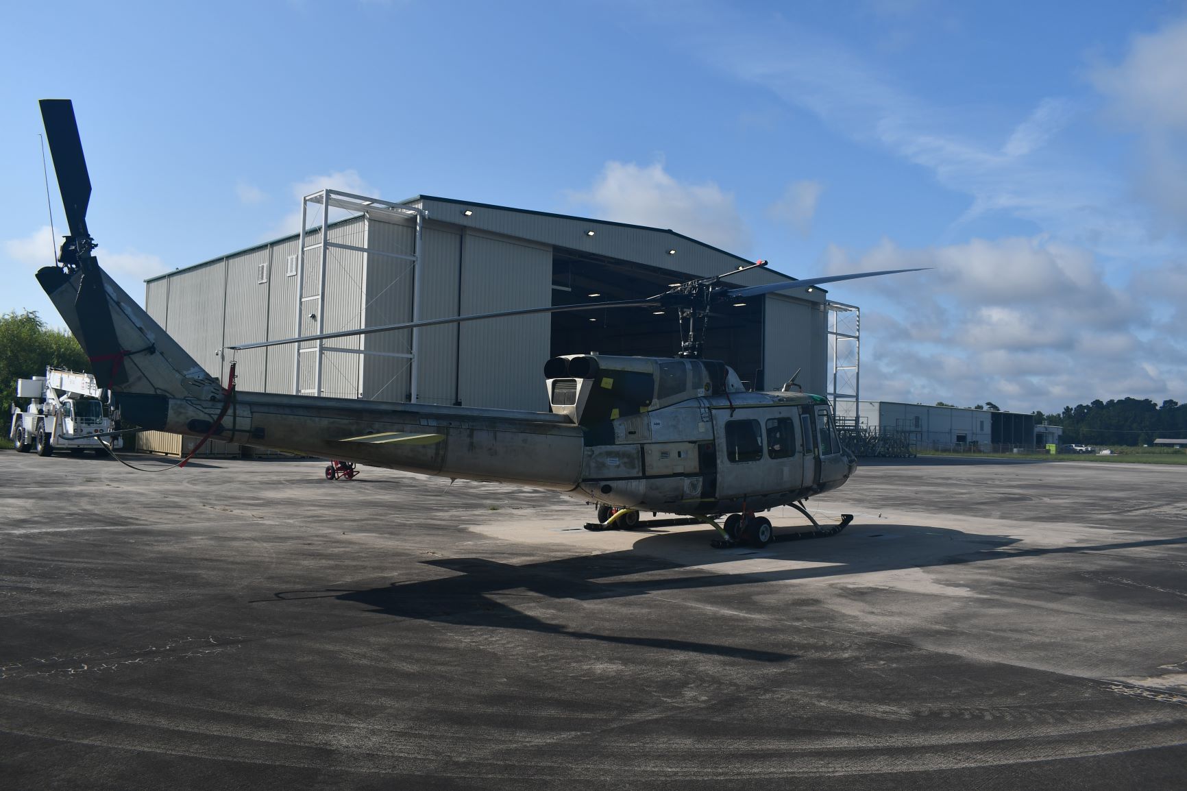 UH-1N "Huey" sits in front of aircraft hangar