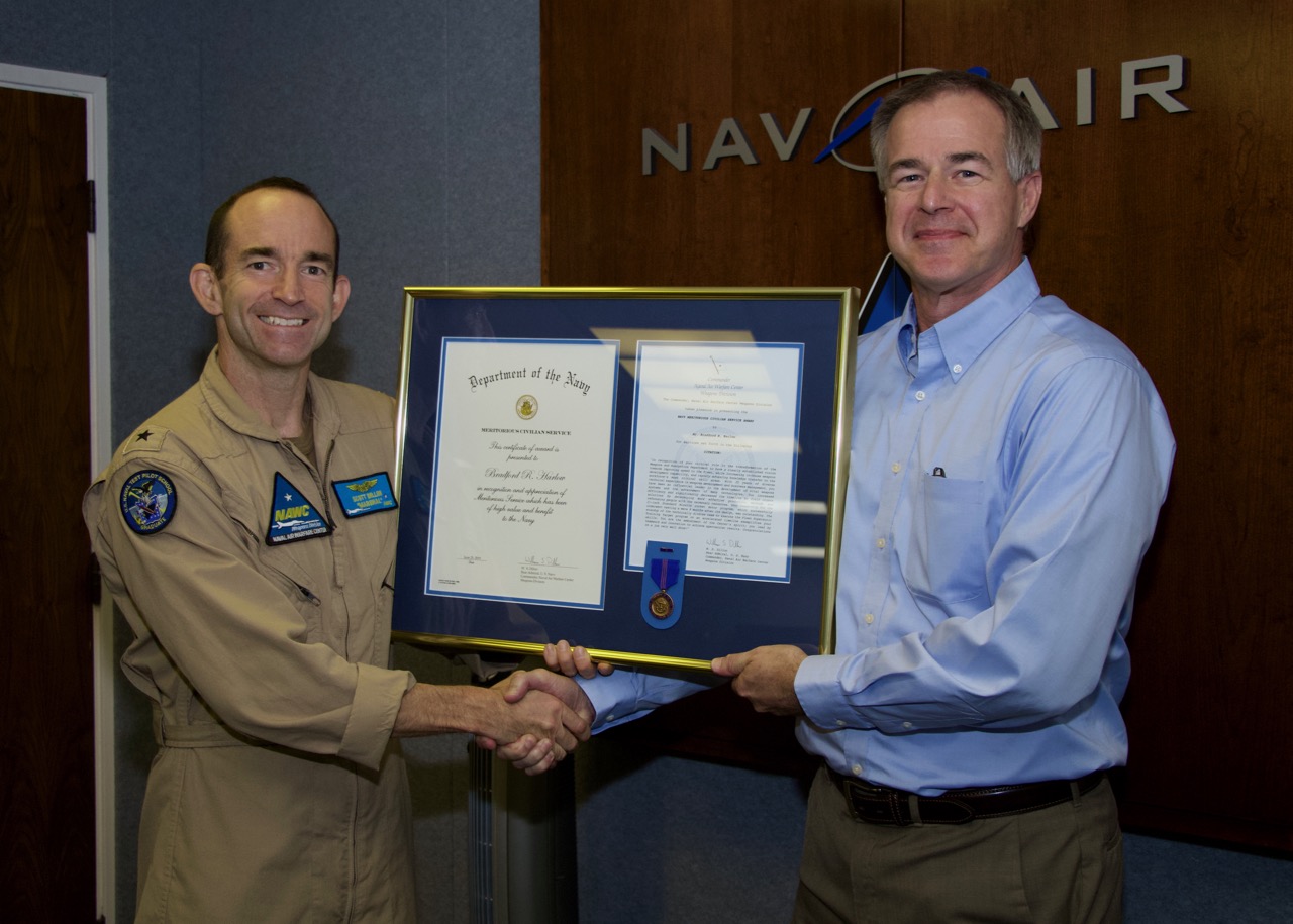 Brad Harlow accepts a Navy Meritorious Civilian Service Award from Rear Adm. Scott Dillon, NAWCWD commander, during a ceremony Aug. 29 at China Lake. (U.S. Navy photo by Paul Kakert)