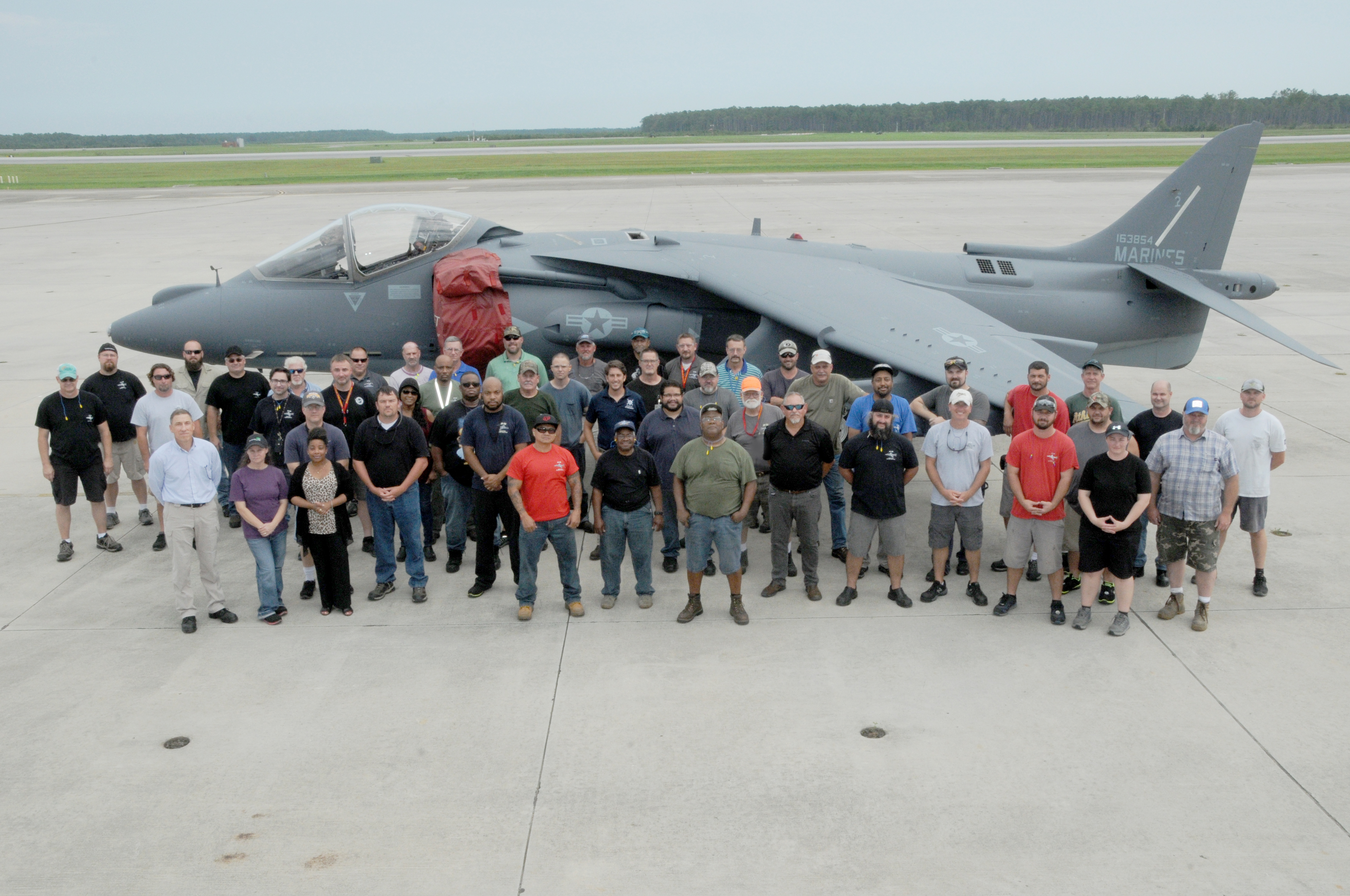 Group photo of Harrier team with final USMC jet