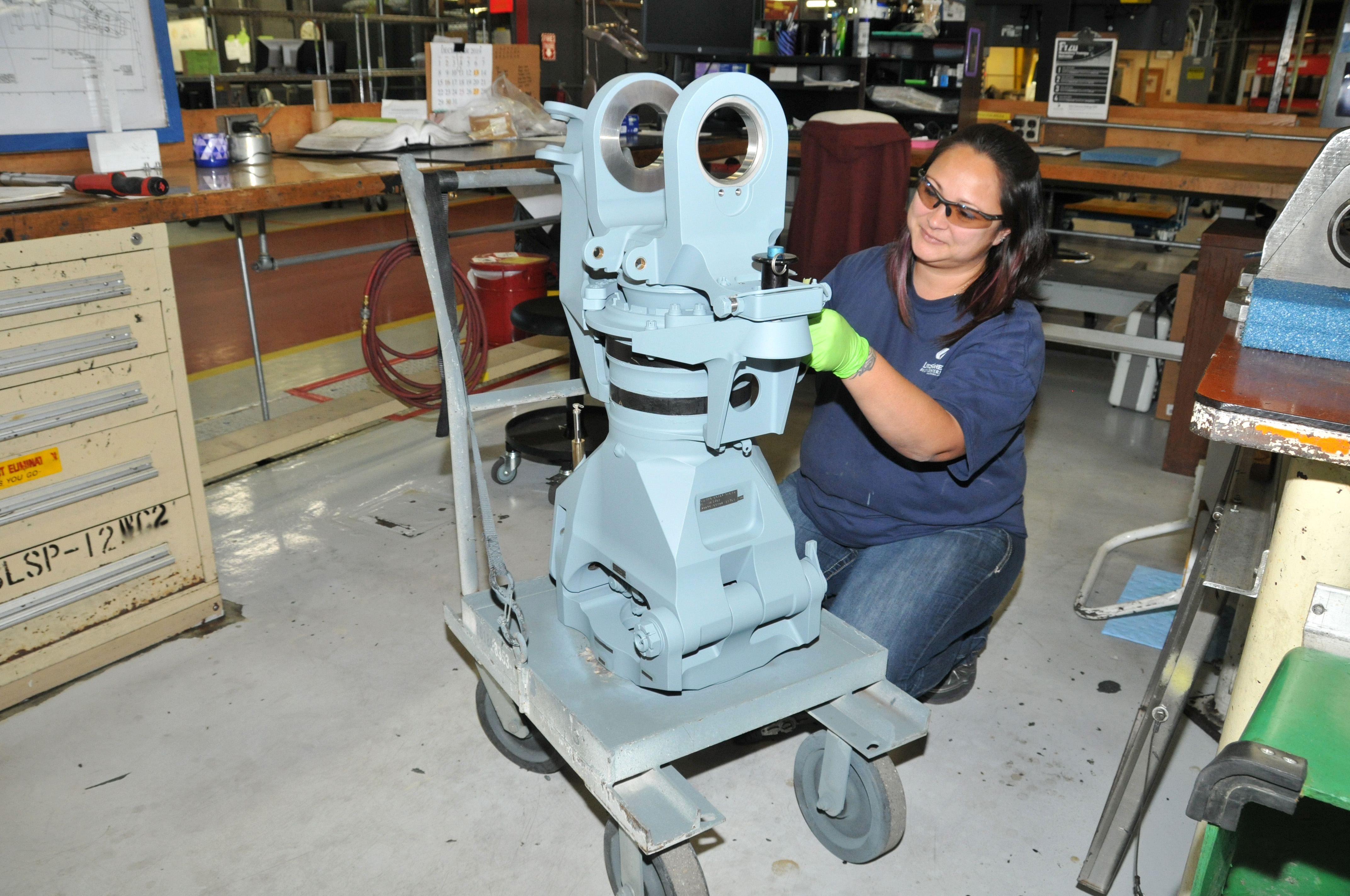 Aircraft mechanical parts repairer inspects a sleeve and spindle for an H-53 helicopter rotor head
