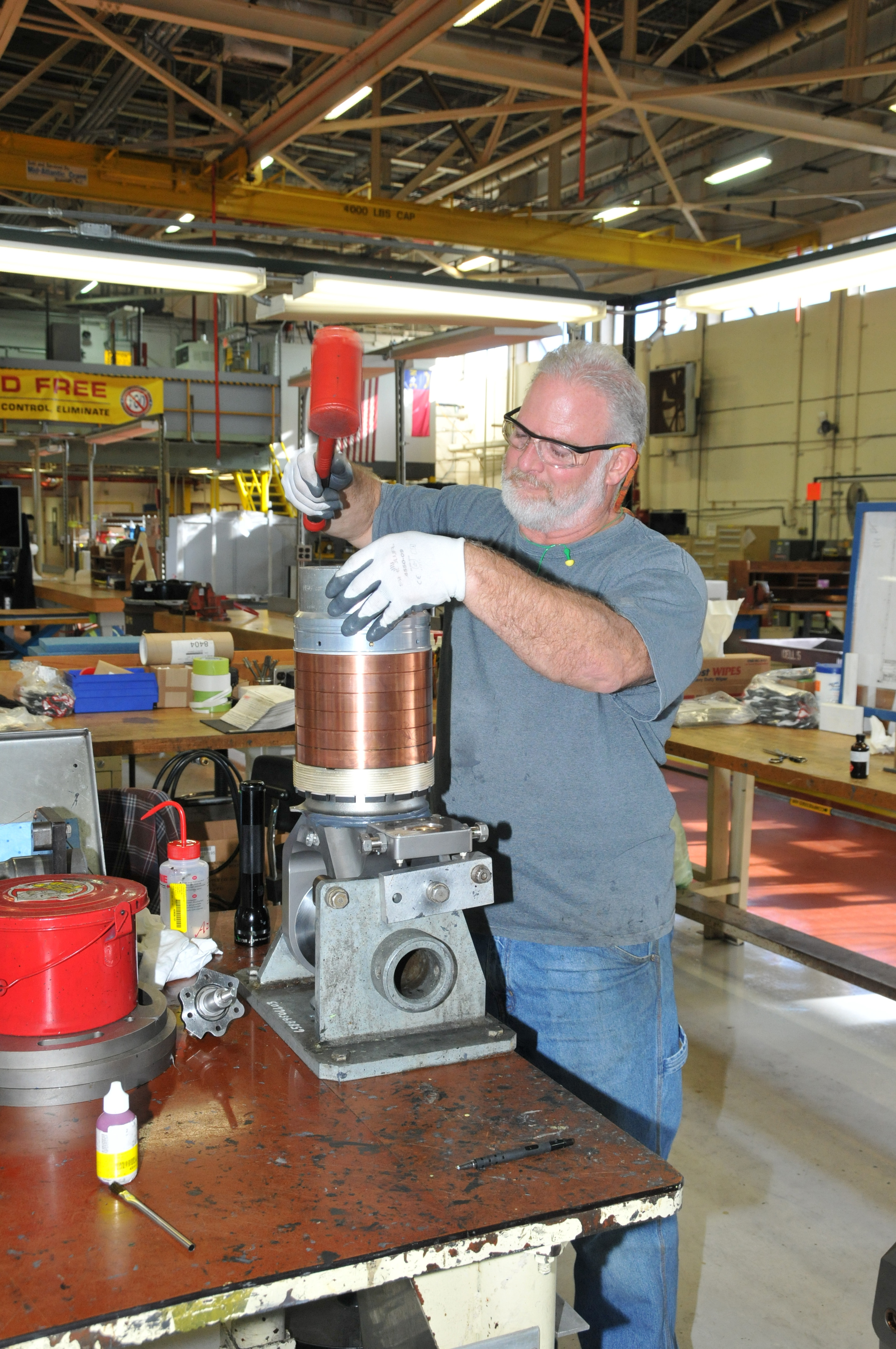 Aircraft mechanic works on a bearing stack-up for an H-53 helicopter rotor head