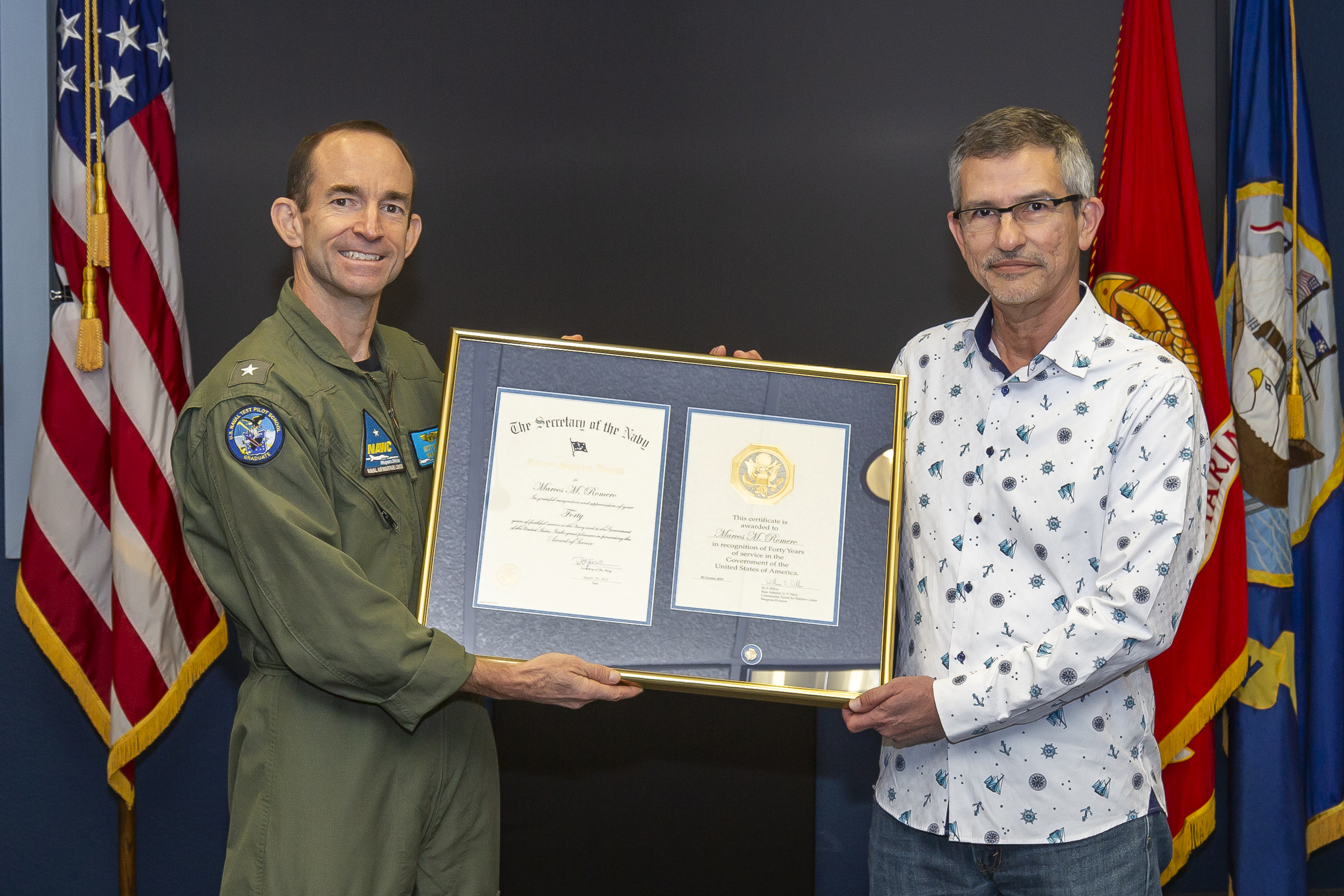 Rear Adm. Scott Dillon presents a 40-year length-of-service award to Marc Romero