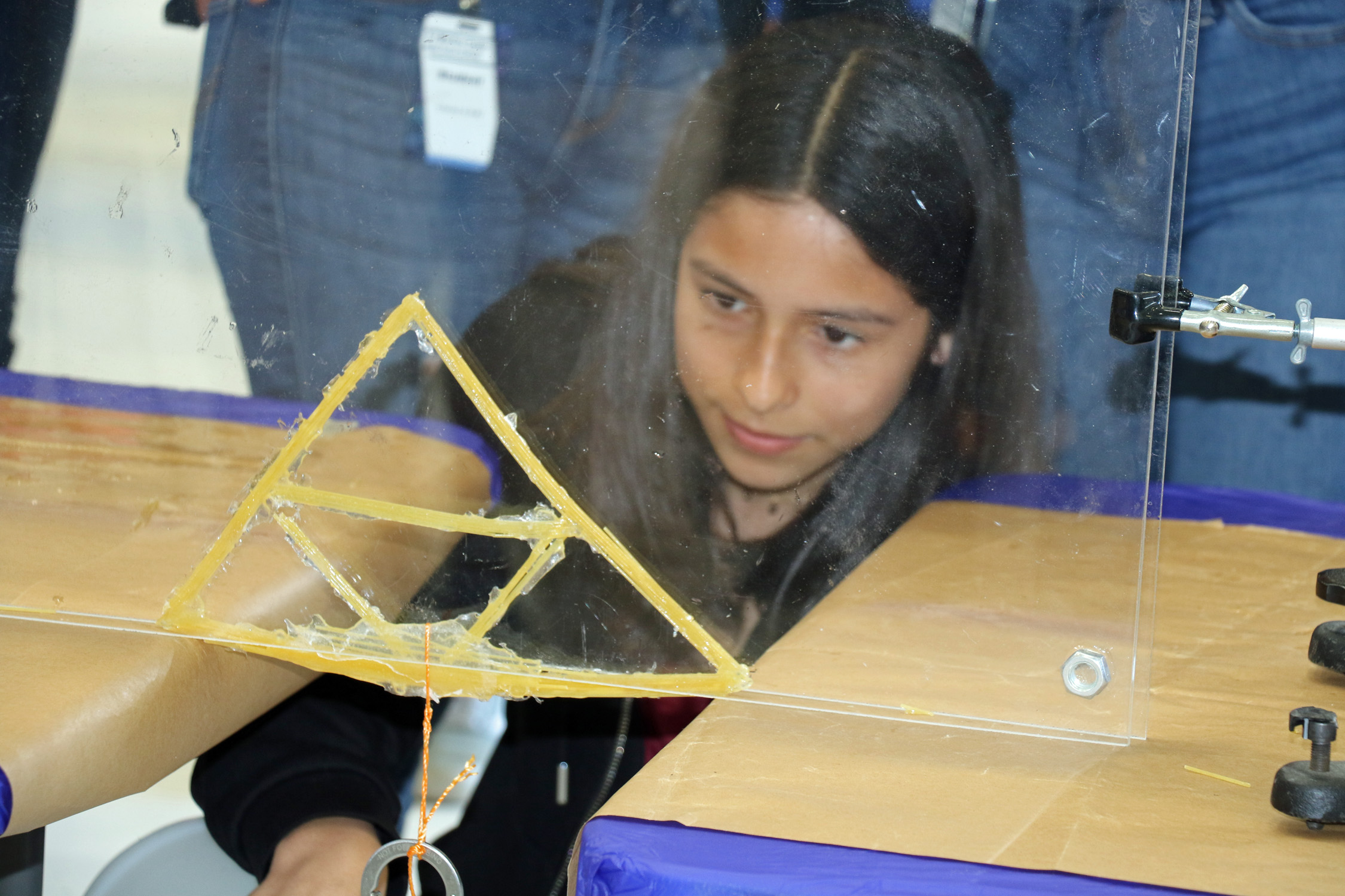 A student from Cesar Chavez Middle School tests their bridge during the annual Tri-Warfare Center STEM Challenge in Point Mugu, California, on Feb. 20. (U.S. Navy photo by Kimberly Brown)