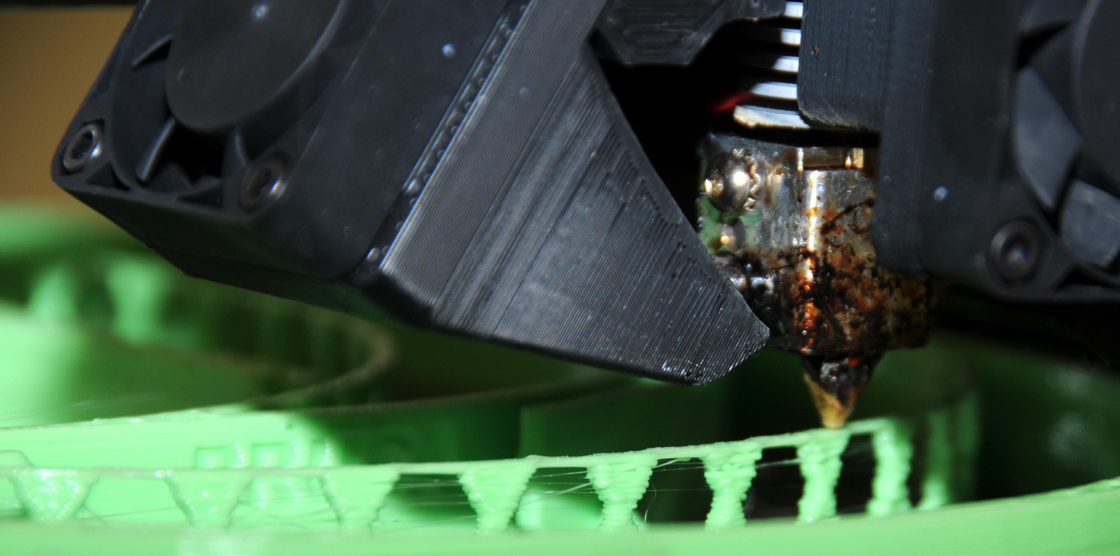 3D printer nozzle lays down layers of thermal plastic to produce a headband