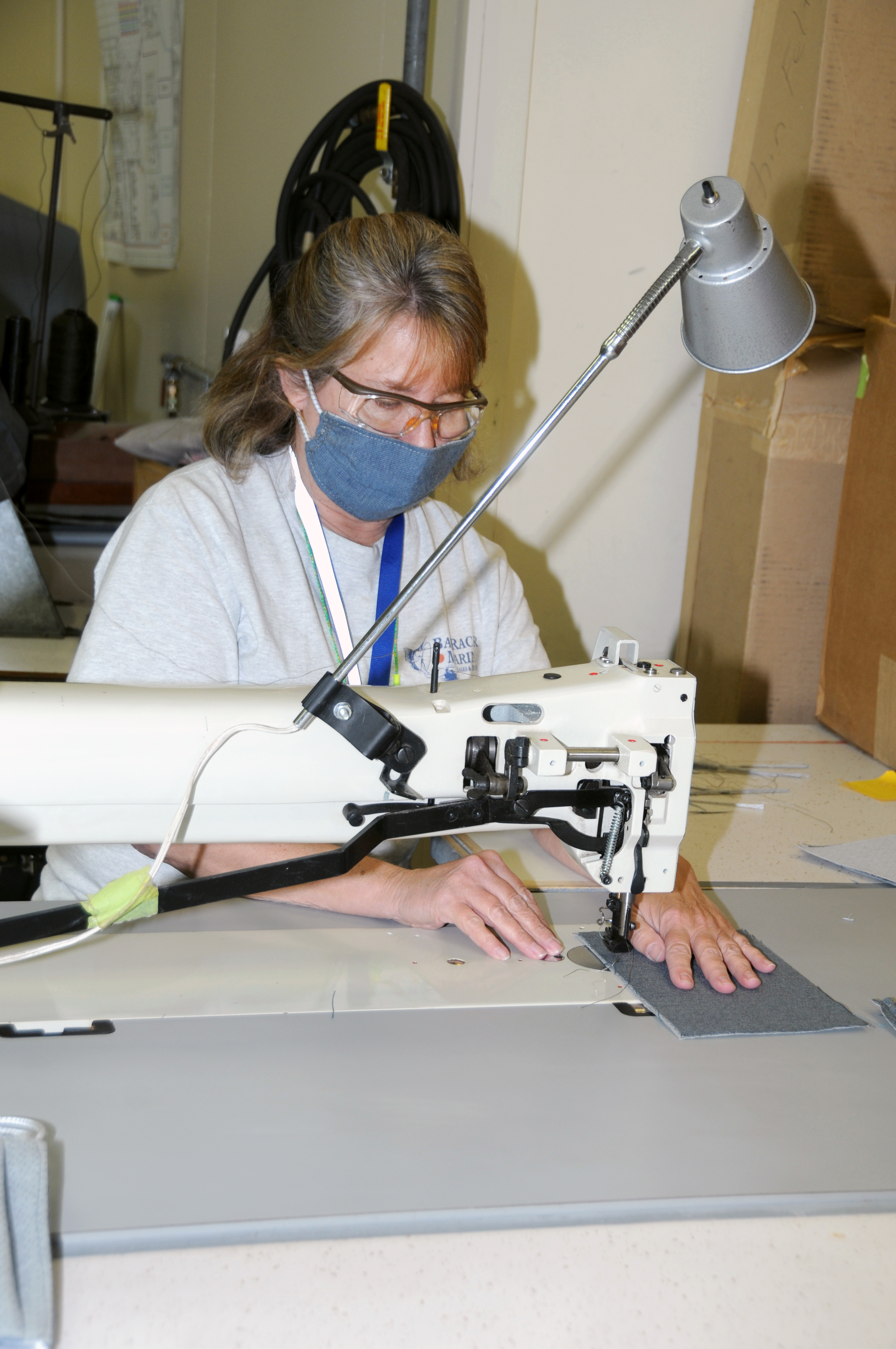 Woman uses sewing machine to make cloth face covering