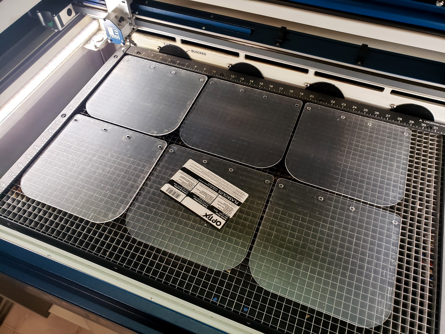 A batch of acrylic face shields made by Lt. Gavin “Flanders” Kurey and his wife Katie, using the industrial laser cutter at their metalworking shop, are ready for assembly with 3D printed headbands for donation to local hospitals and medical clinics. (U.S. Navy photo by Lt. Gavin Kurey)