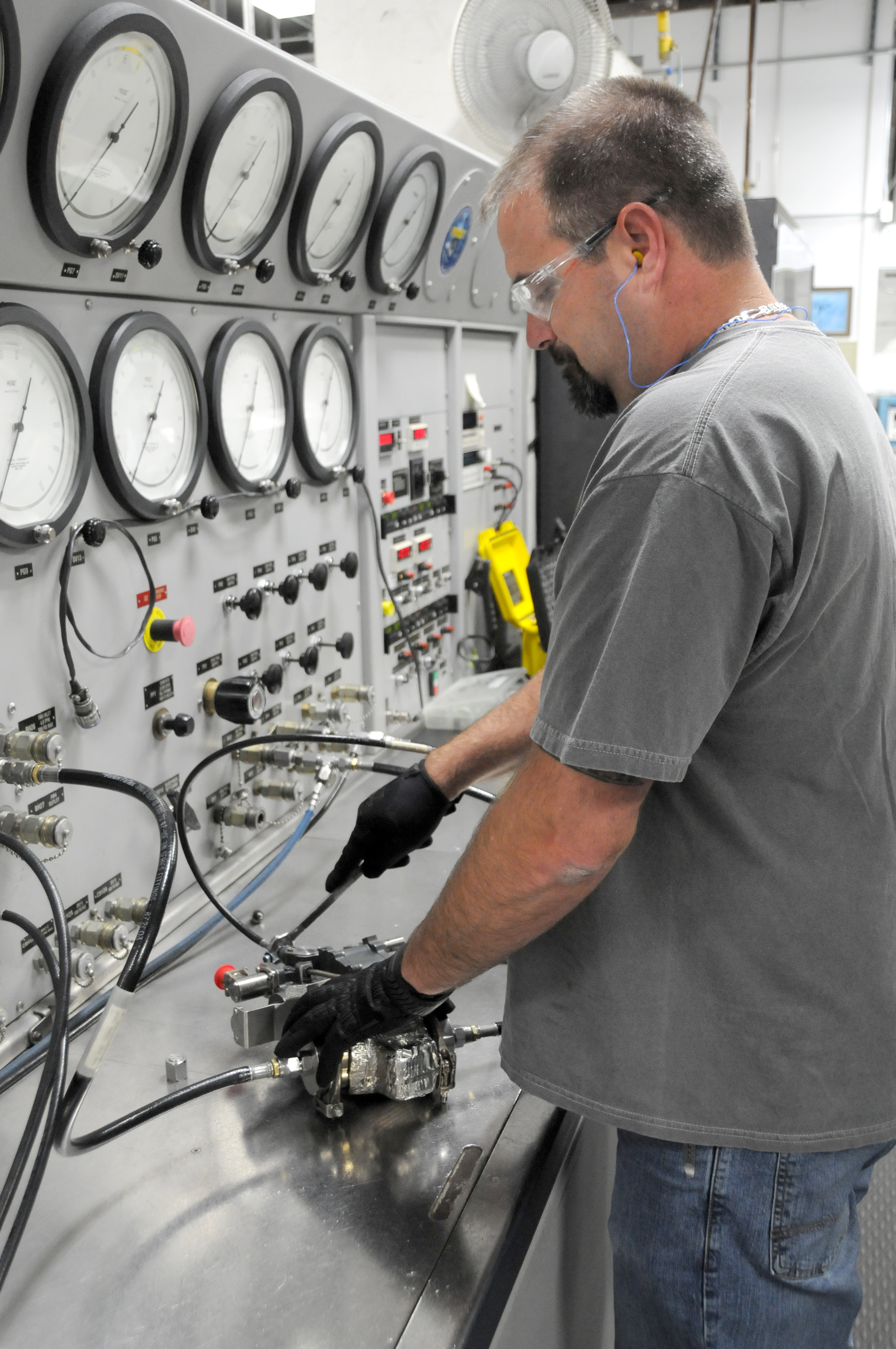 Man prepares to check F-35 valve on test stand