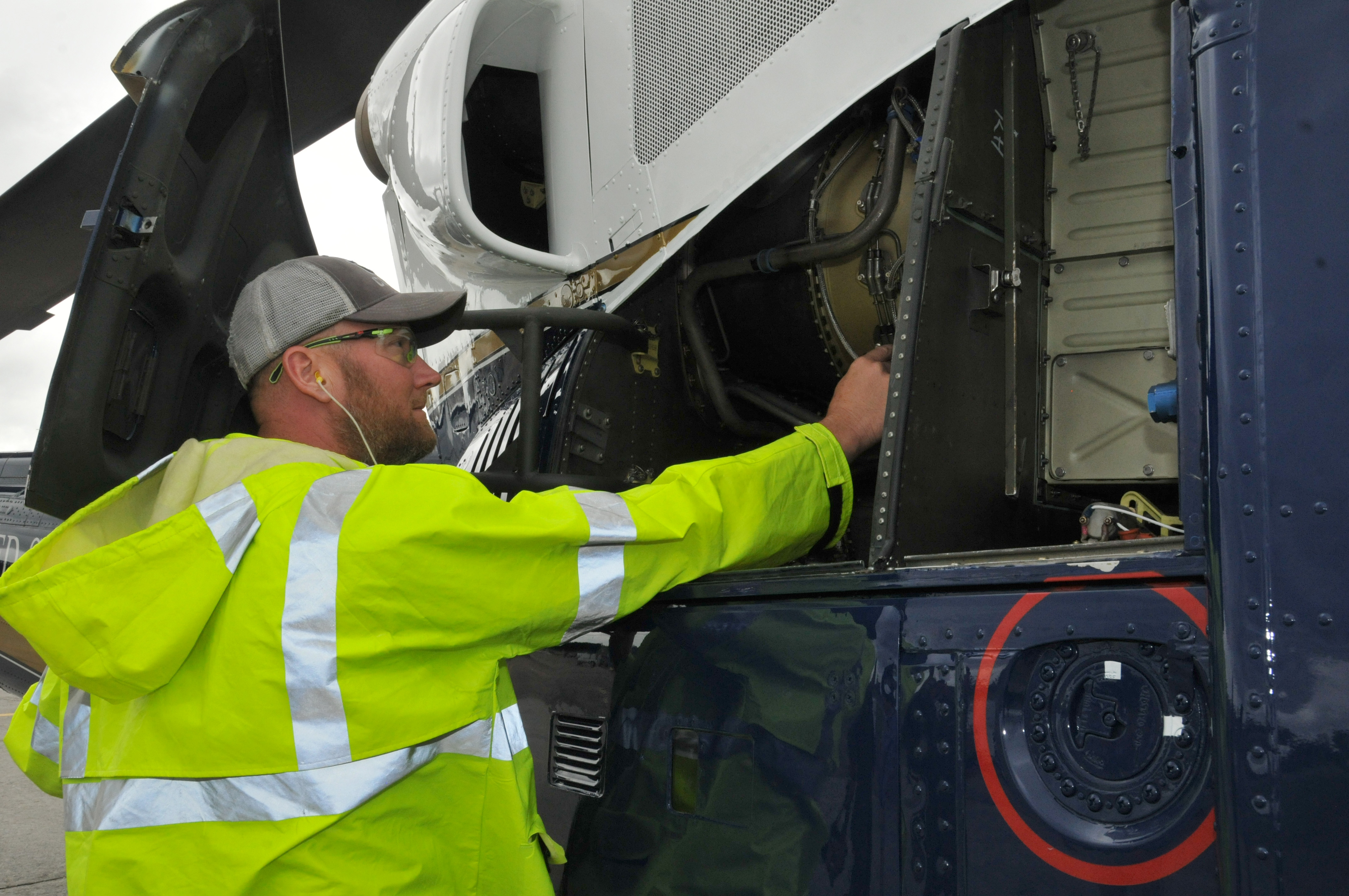 FRCE mechanic inspects H-1 helicopter before test flight.