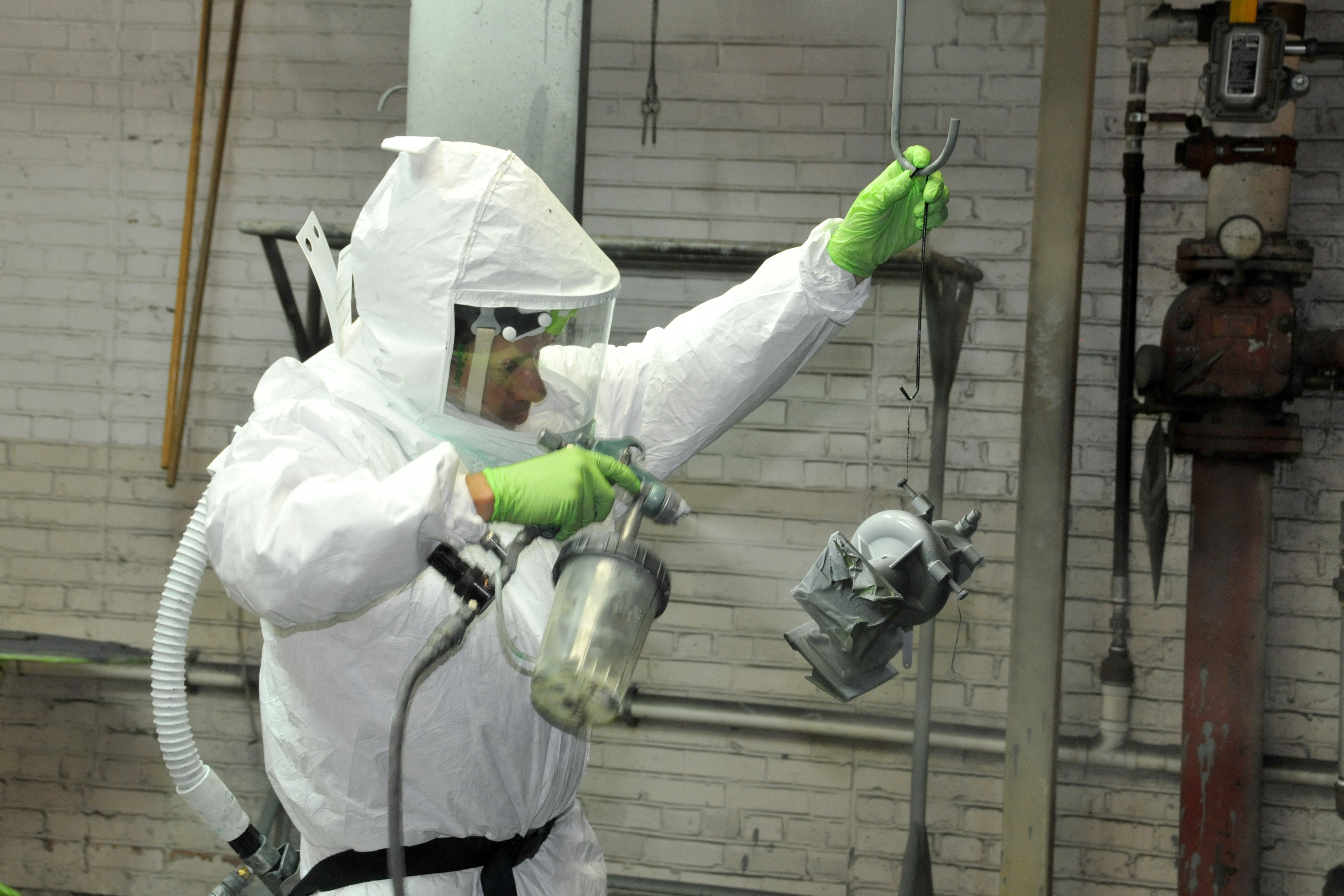 Painter primes a V-22 part to prepare it for painting.
