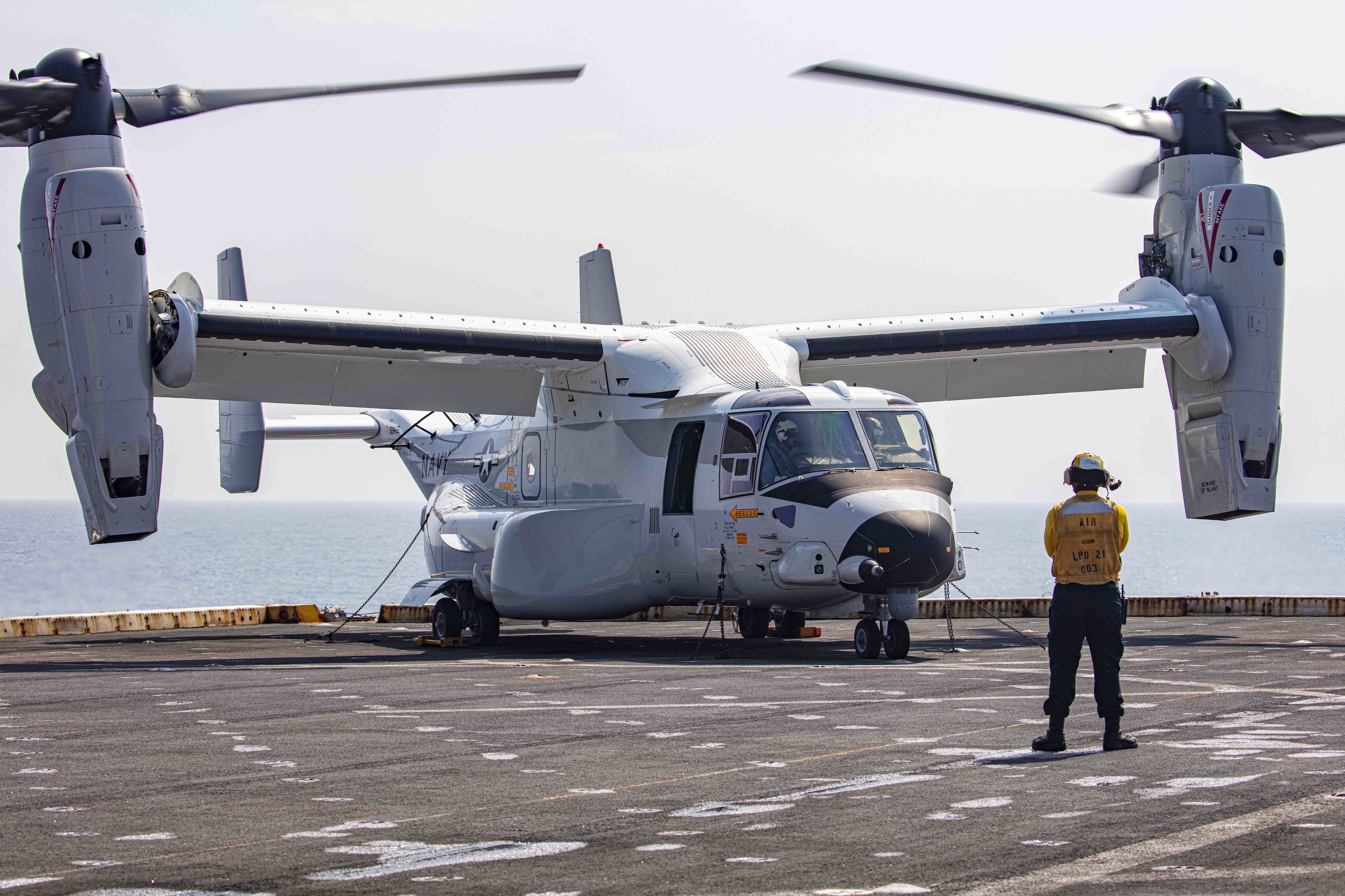 Aviation Boatswain’s Mate (Handling) 3rd Class Lorenzo Moreno, assigned to the transport dock ship USS New York (LPD 21), signals to a CMV-22B Osprey attached to the Blackjacks of Air Test and Evaluation Squadron (HX) 21 on the New York's flight deck on July 18, 2020. (U.S. Navy photo)