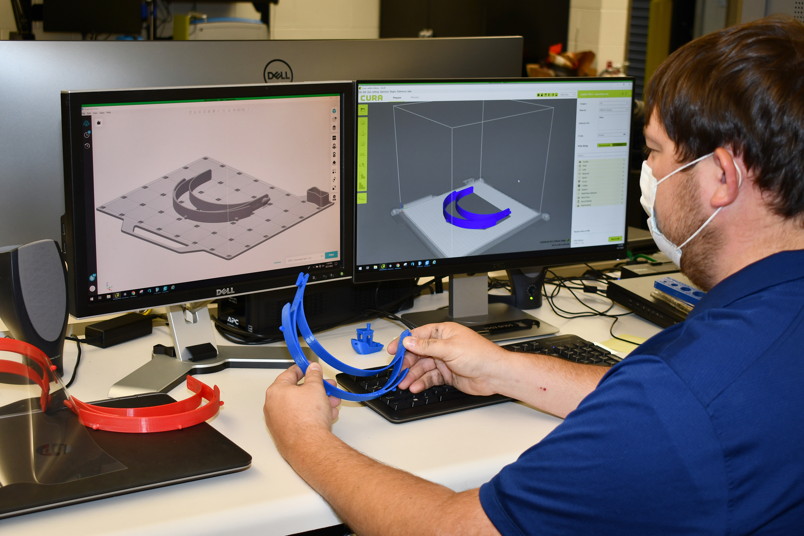 Man compares 3D-printed plastic headband to model on computer screen