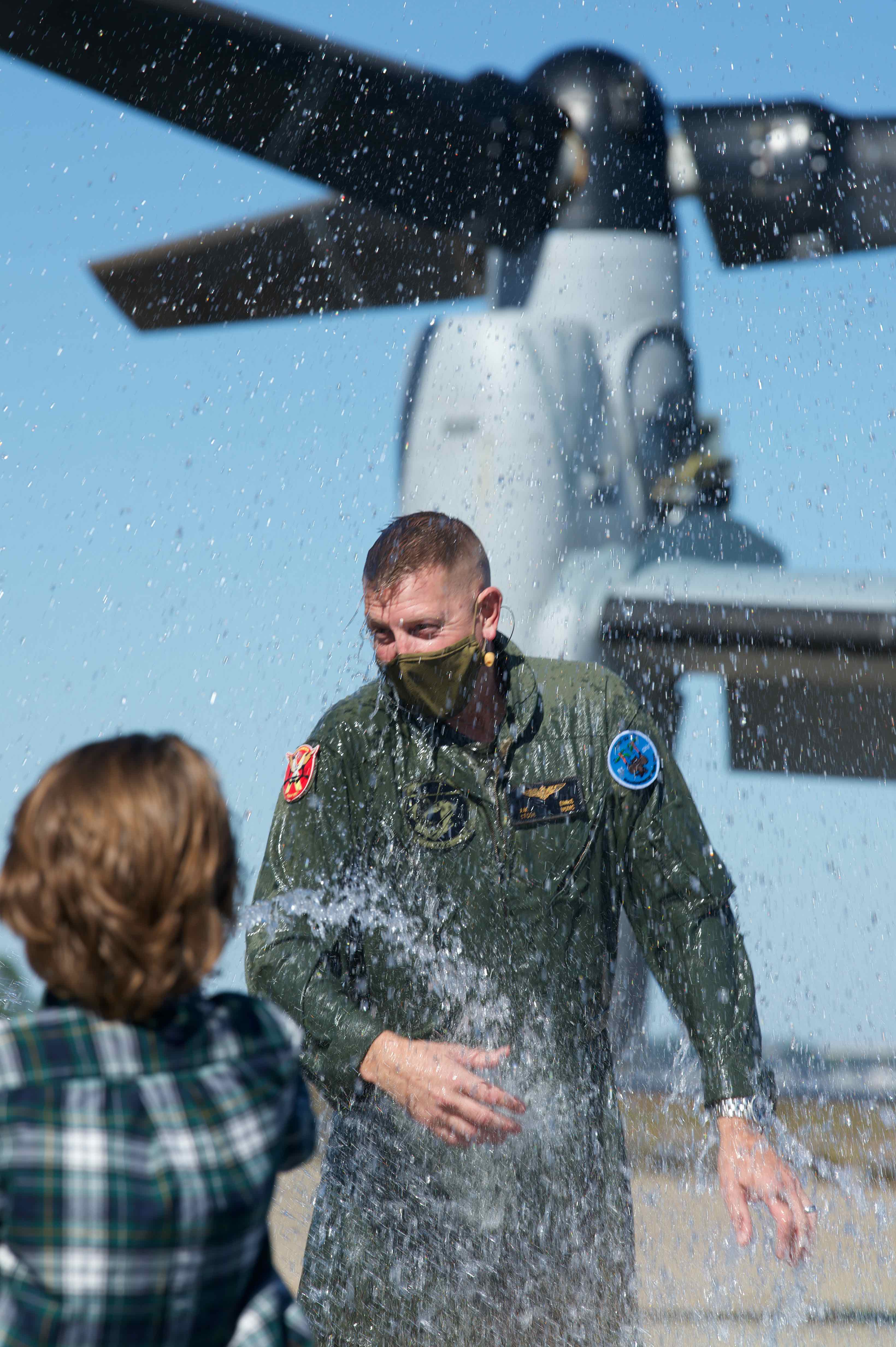 Lt. Col. John Ennis reacts to being doused by his son following a ceremonial airborne passing of the command on Oct. 9, 2020, part of the change of command ceremony for Air Test and Evaluation Squadron (HX) 21 during which Ennis was relieved by Cmdr. Daniel Short, the squadron’s chief test pilot. (U.S. Navy photo by Paul Lagasse)