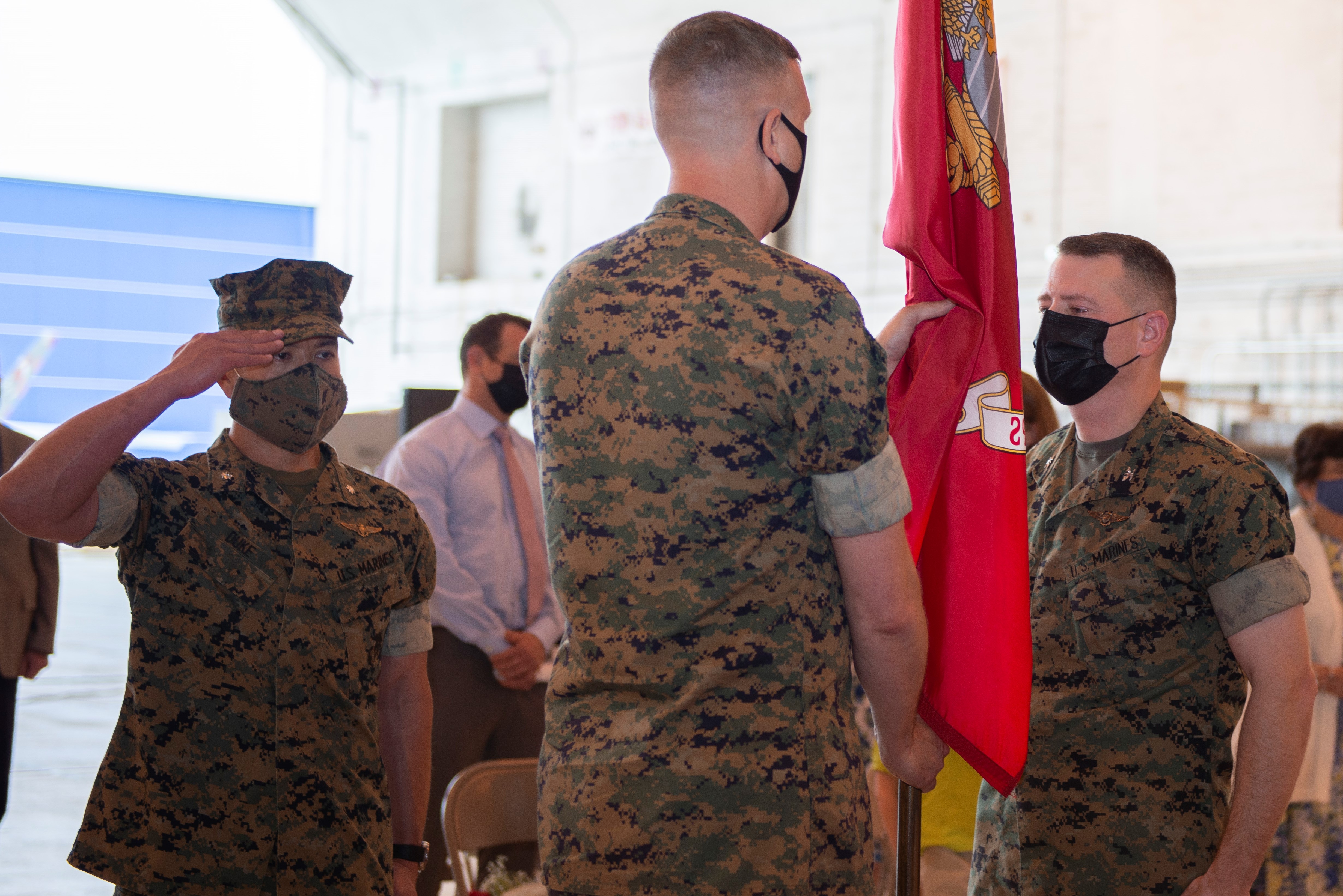Col. Brian Taylor (left) relieves Col. Matthew Kelly (right) as the program manager of the V-22 Joint Program Office (PMA-275) during a change of command ceremony at Naval Air Station Patuxent River Apr. 29. Lt. Col. Jason Duke, master of ceremonies, salutes during the passing of the colors. 