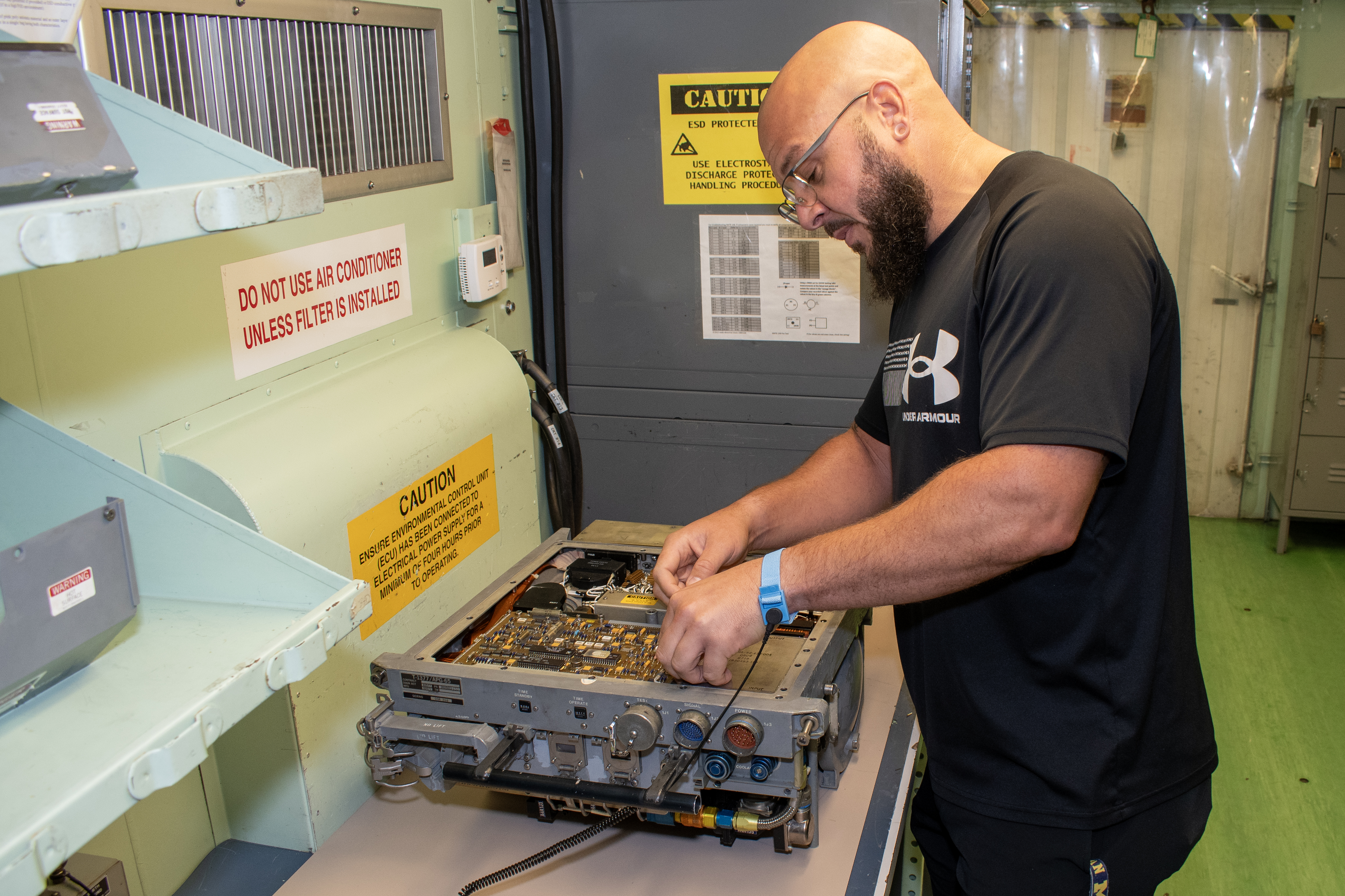 Civilian electronics integrated system mechanic works with a radar transmitter from an F/A-18 Hornet.