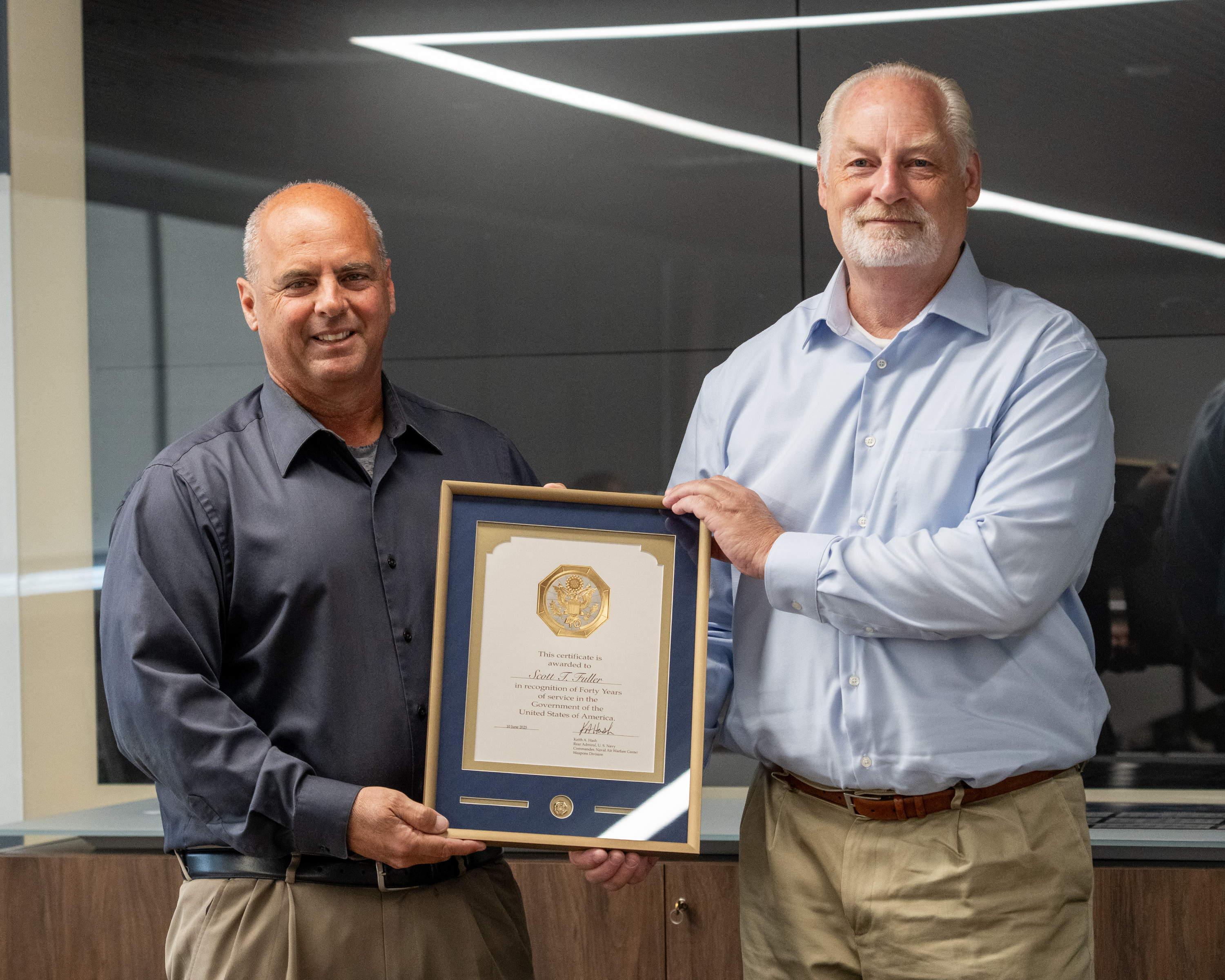 Naval Air Warfare Center Weapons Division Director for Energetics Scott Fuller (right) poses with Executive Director Dan Carreño during a ceremony in China Lake on June 4 honoring Fuller for 40 years of service to the government. (U.S. Navy photo by Ryan Smith)