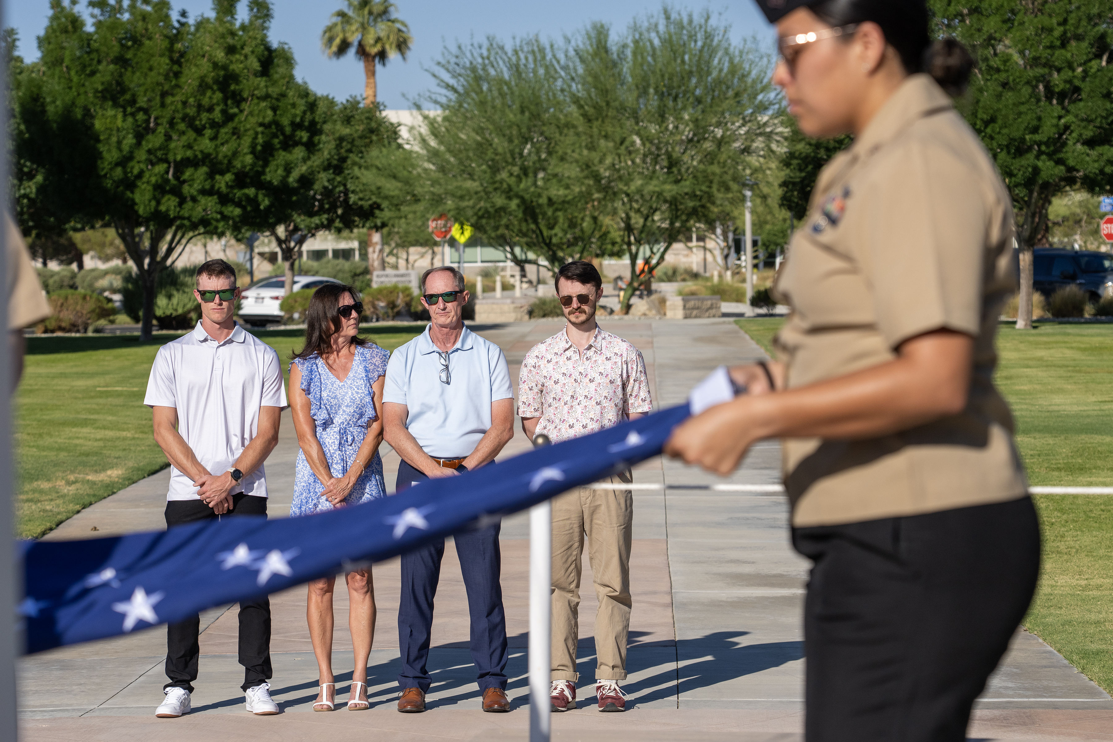Richard Cracraft (second from left), stands with his wife, Laurie, and their two sons, while being presented with a flag honoring his 38 years of federal service during a ceremony July 11 in China Lake, Calif. 