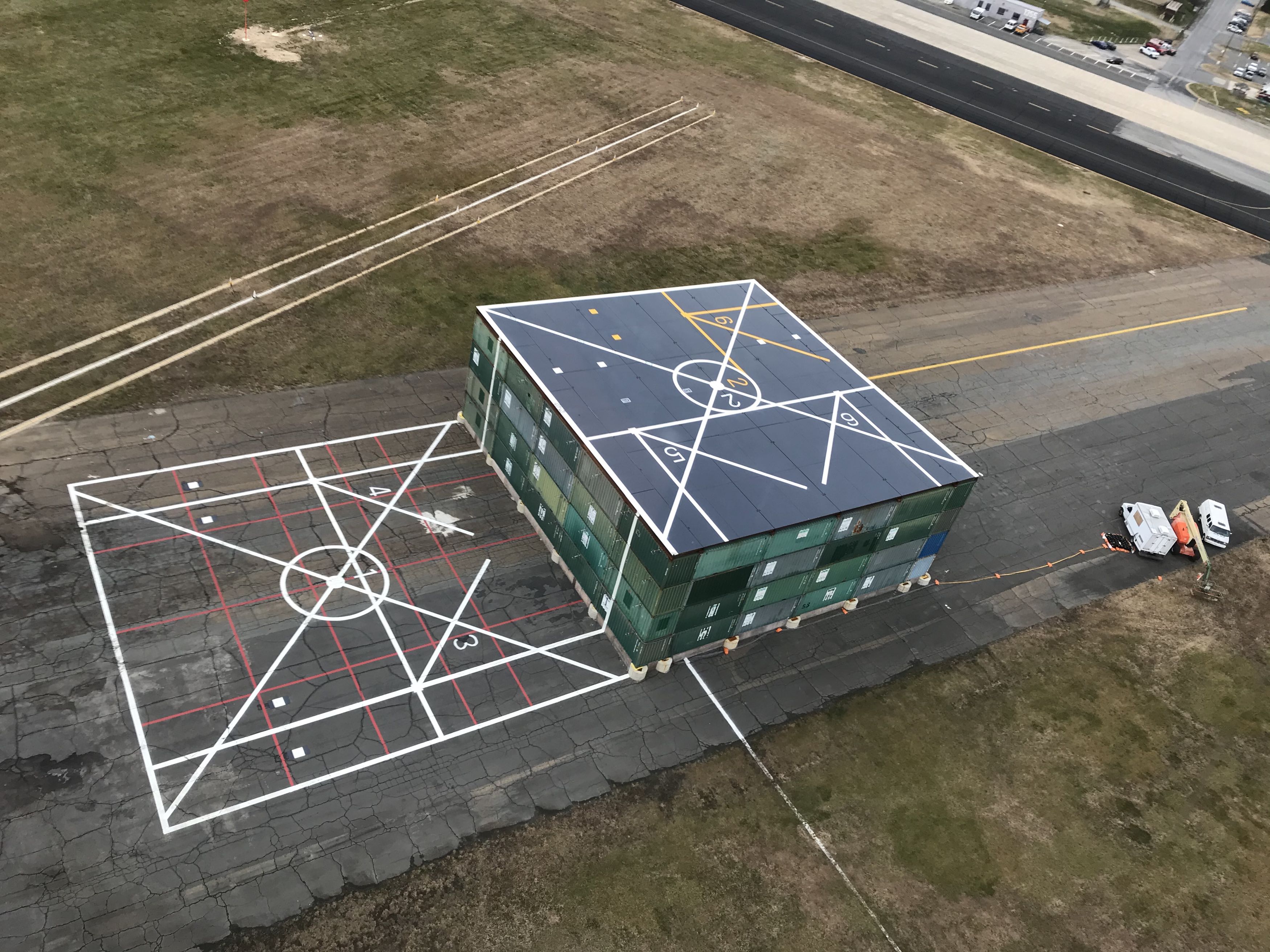 A helicopter’s-eye view of the Elevated Fixed Platform (EFP), a test platform constructed on a disused taxiway at Naval Air Station Patuxent River for testing recirculation effects on the V-22 Osprey. Upon completion of those tests, two U.S. Naval Test Pilot School instructors seized the opportunity before the EFP was dismantled to conduct a flight test program that they hope will lead to a better understanding of how helicopters behave when landing on and taking off from ships at sea, rooftop platforms, an