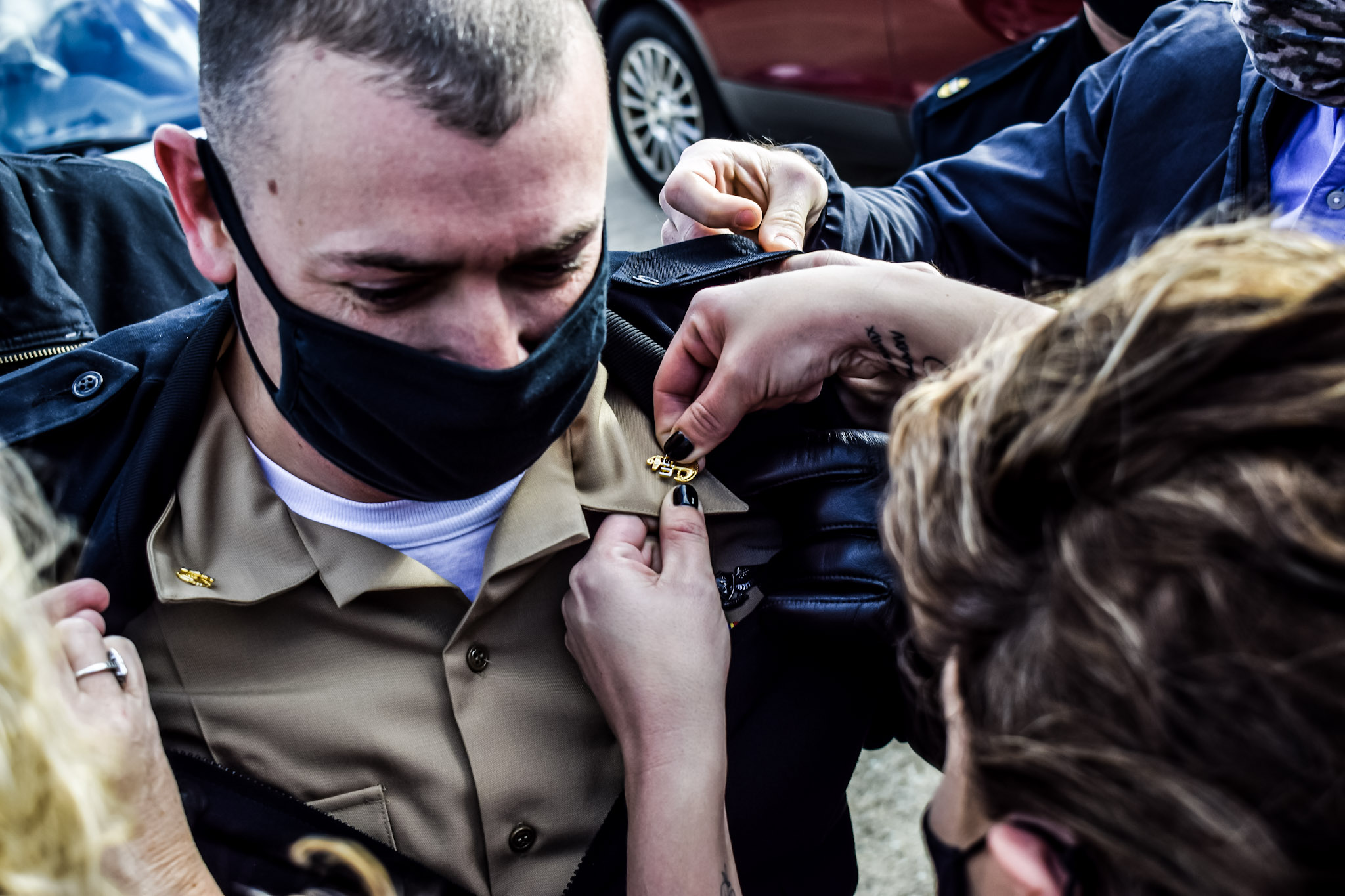 Chief Aviation Electronics Technician Joshua Coughlin receives his anchors from family members during a chief petty officer (CPO) pinning ceremony hosted by the U.S. Naval Test Pilot School at Naval Air Station Patuxent River on Jan. 29, 2021.