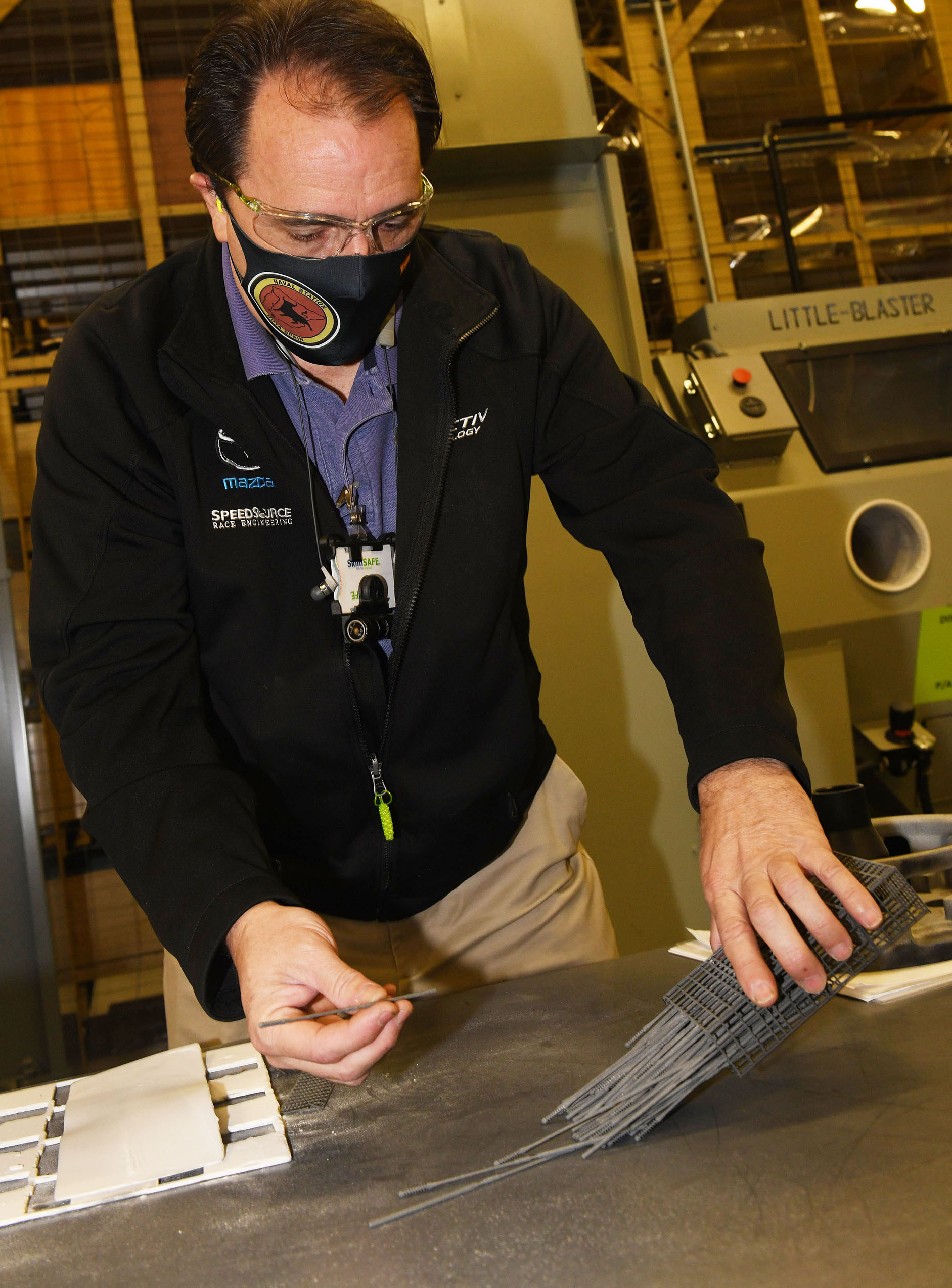 Fleet Readiness Center Southeast (FRCSE) Tool Designer Randy Meeker opens a nasopharyngeal swab cage. 