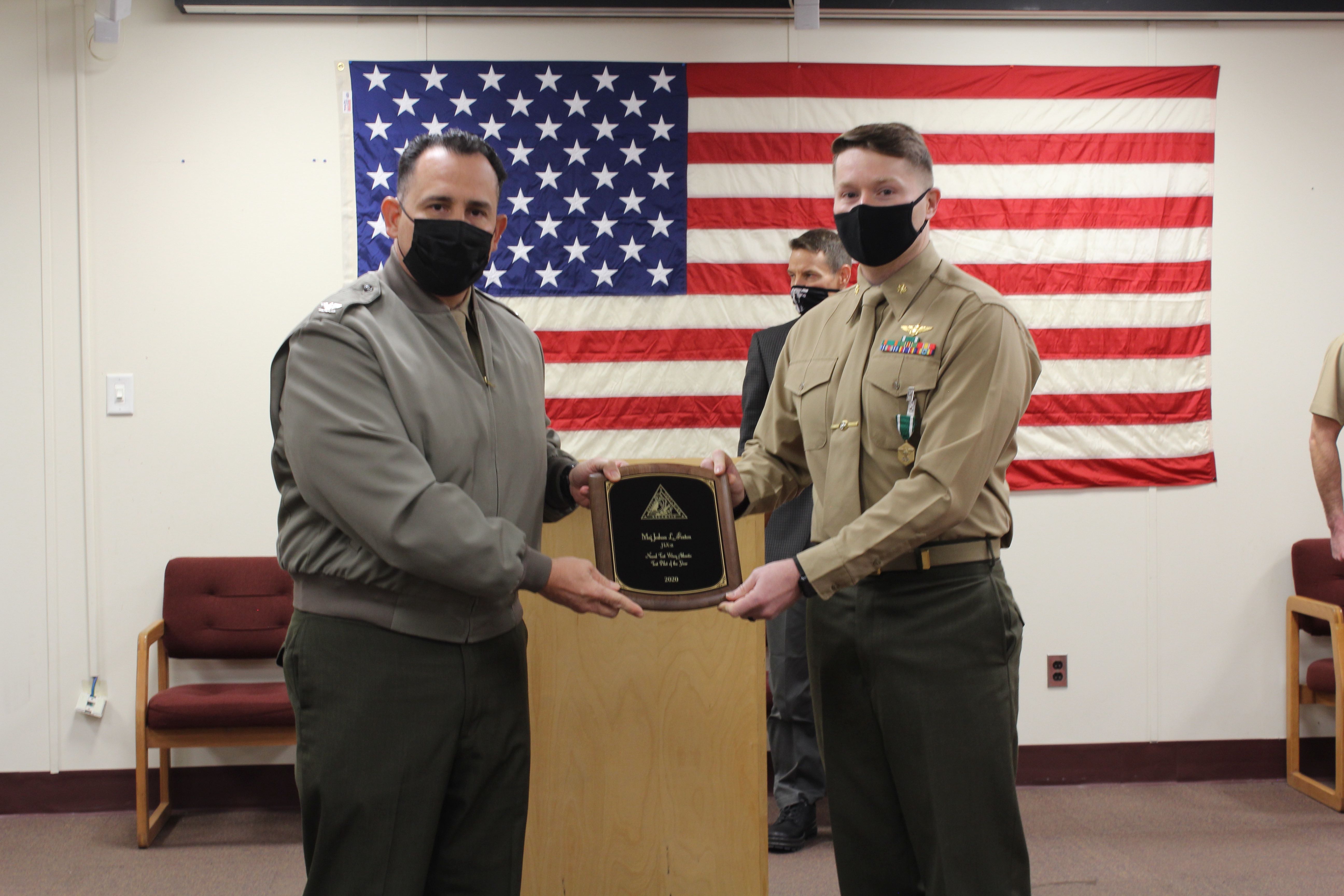 Col. Richard E. Marigliano, commander of Naval Test Wing Atlantic (NTWL), left, presents Air Test and Evaluation Squadron (HX) 21 pilot Maj. Joshua Foxton with NTWL's Test Pilot of the Year award for 2020 during a ceremony on February 12 2021.