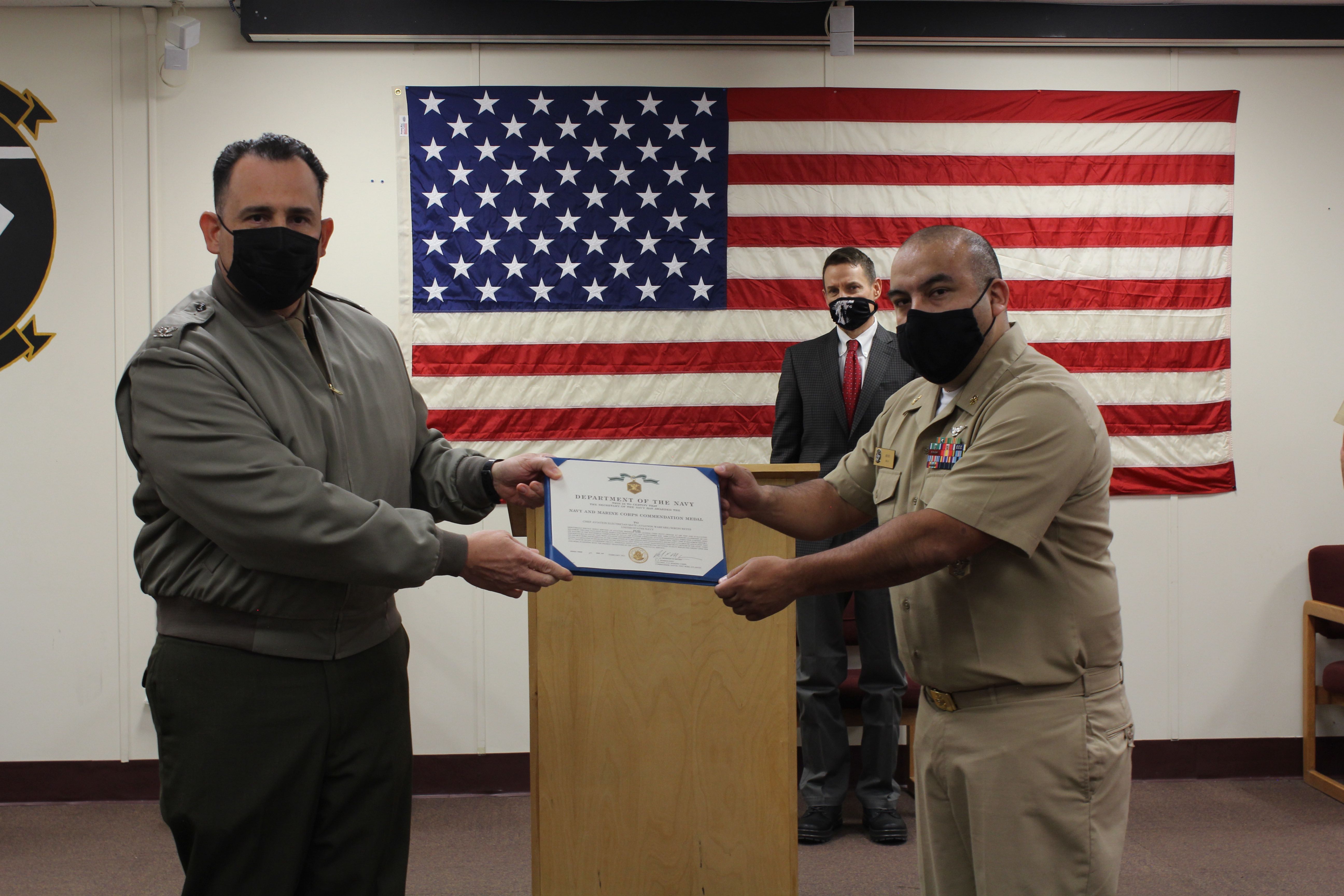 Col. Richard E. Marigliano, commander of Naval Test Wing Atlantic (NTWL), left, presents Chief Aviation Electrician’s Mate (Aviation Warfare) Sergio Reyes of Air Test and Evaluation Squadron (HX) 21 with NTWL's Maintenance Chief Petty Officer of the Year award for 2020 during a ceremony on February 12 2021.