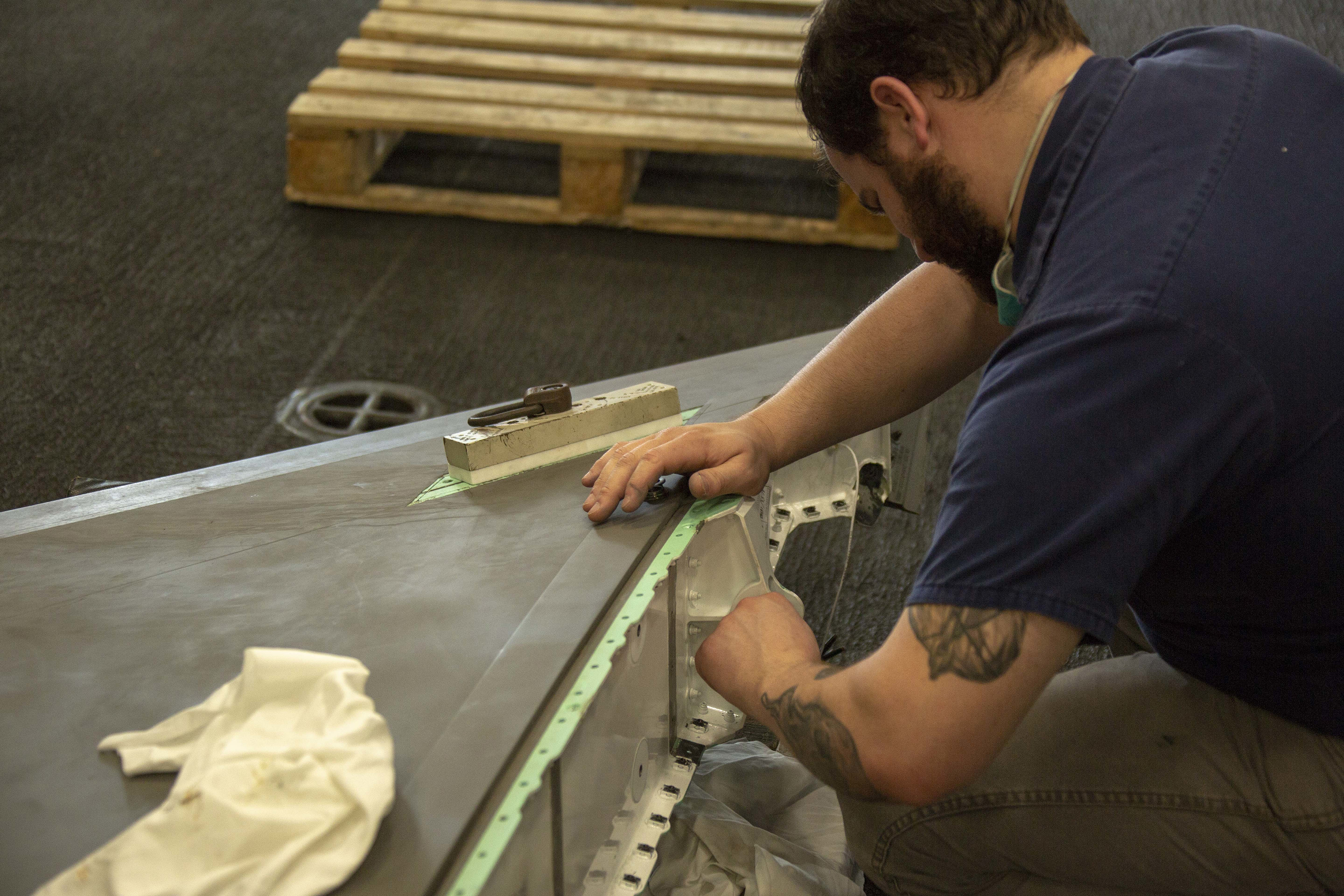 Aircraft mechanic performs cleans bearing on F-35B tail