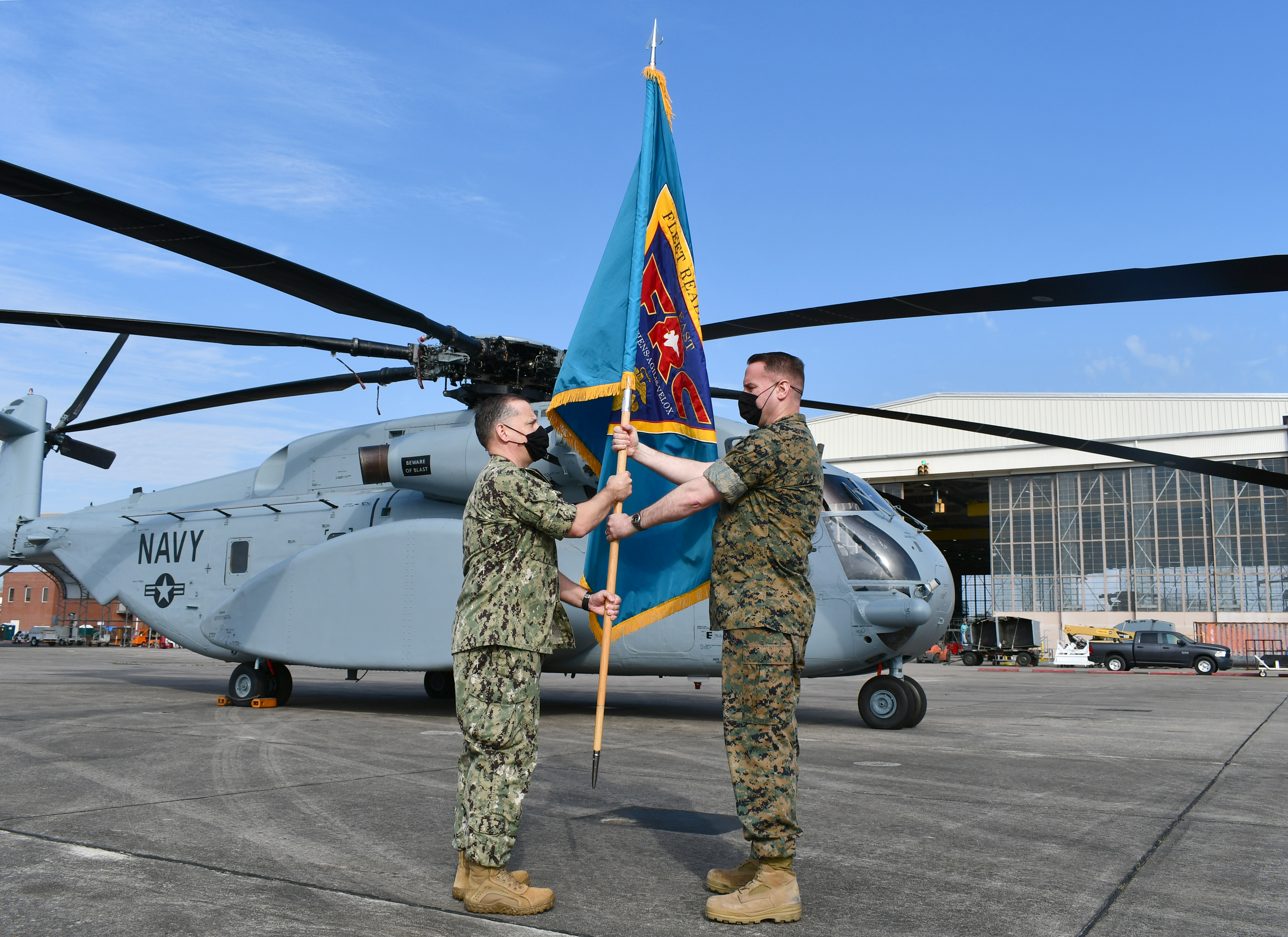 Outgoing Fleet Readiness Center East commander passes guidon to incoming commanding officer