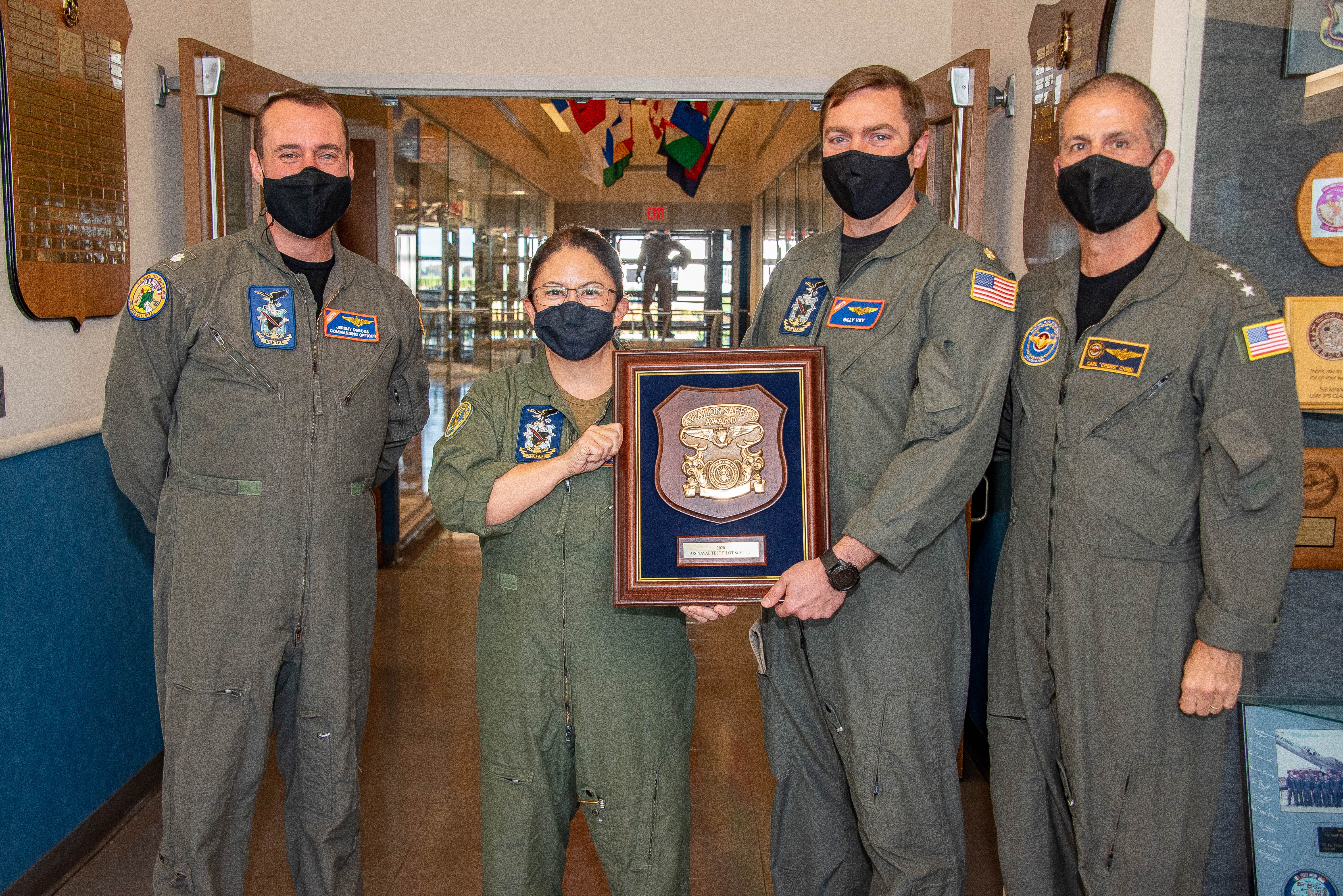 A team from the U.S. Naval Test Pilot School is pictured with an award plaque. 