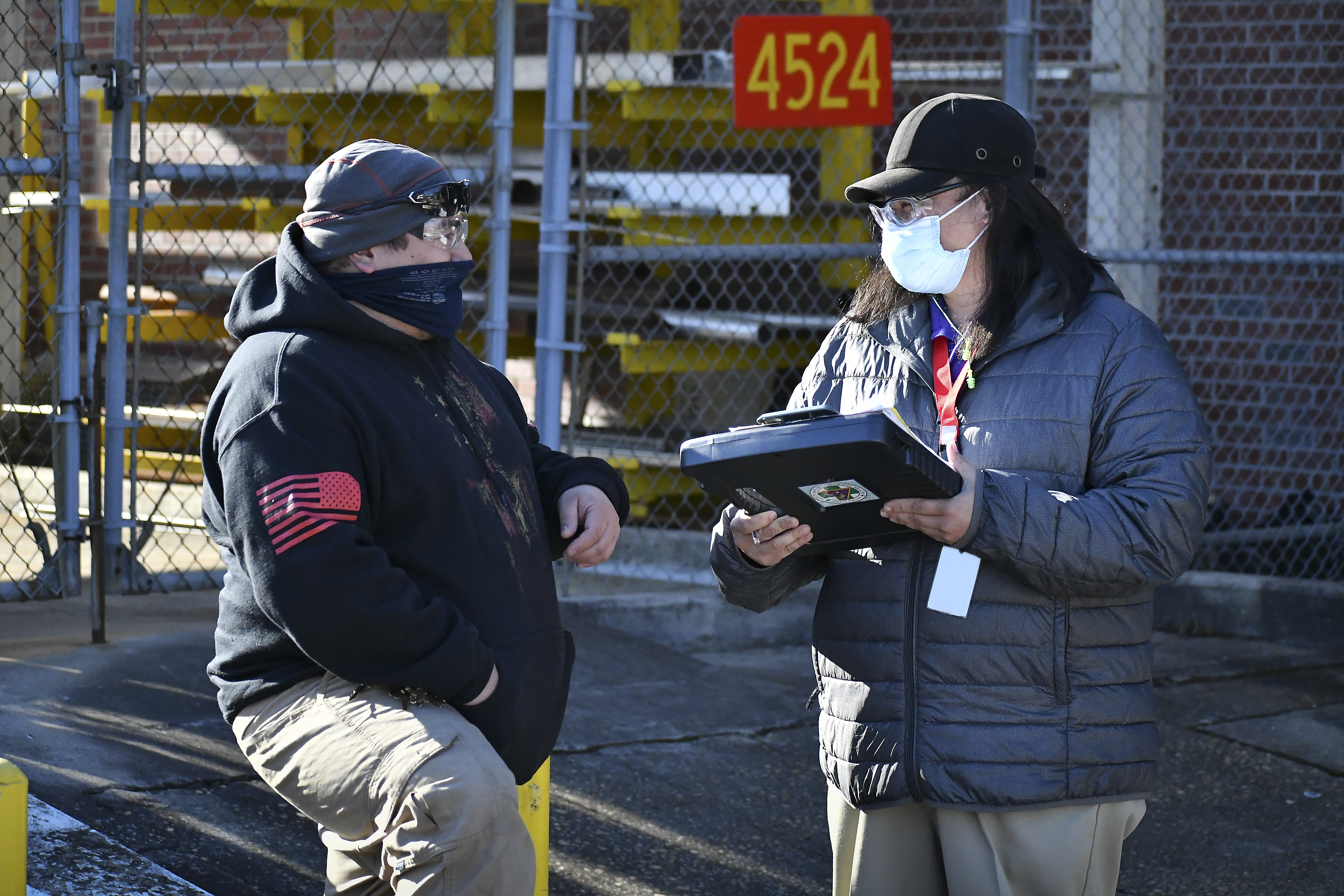 Aquiles Faustino, a safety specialist at Fleet Readiness Center East (FRCE), speaks with Samuel Foreman, an electrical equipment repairer at FRCE, during a safety site survey. 