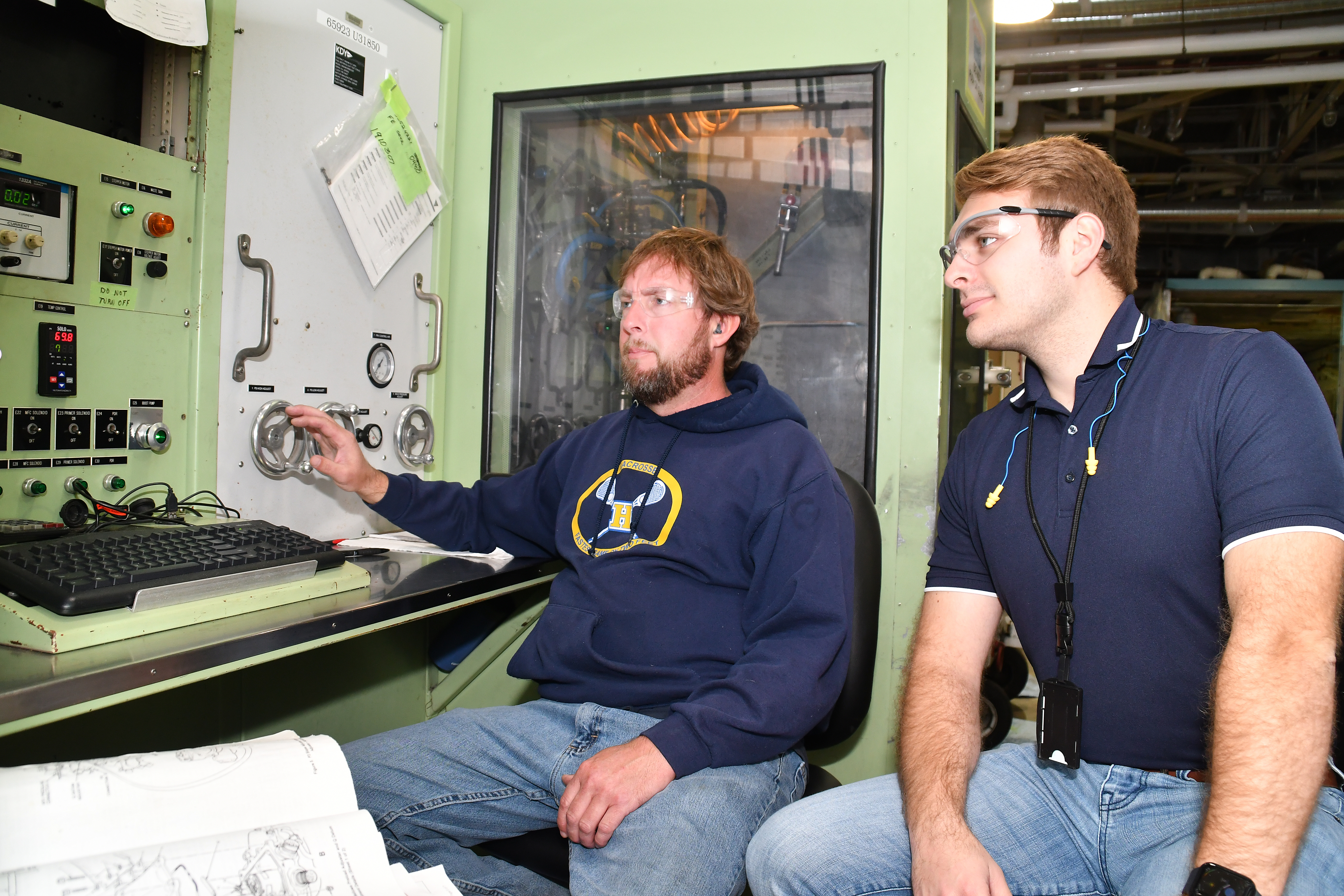 Shawn Kidney, left, a pneudralics systems mechanic at Fleet Readiness Center East (FRCE), and Wyatt Amacker, an aerospace engineer at the depot, test an AV-8B fuel management unit.