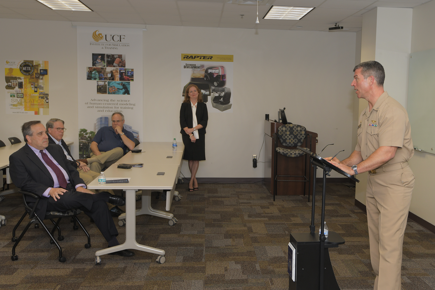Captain speaking at podium in classroom.