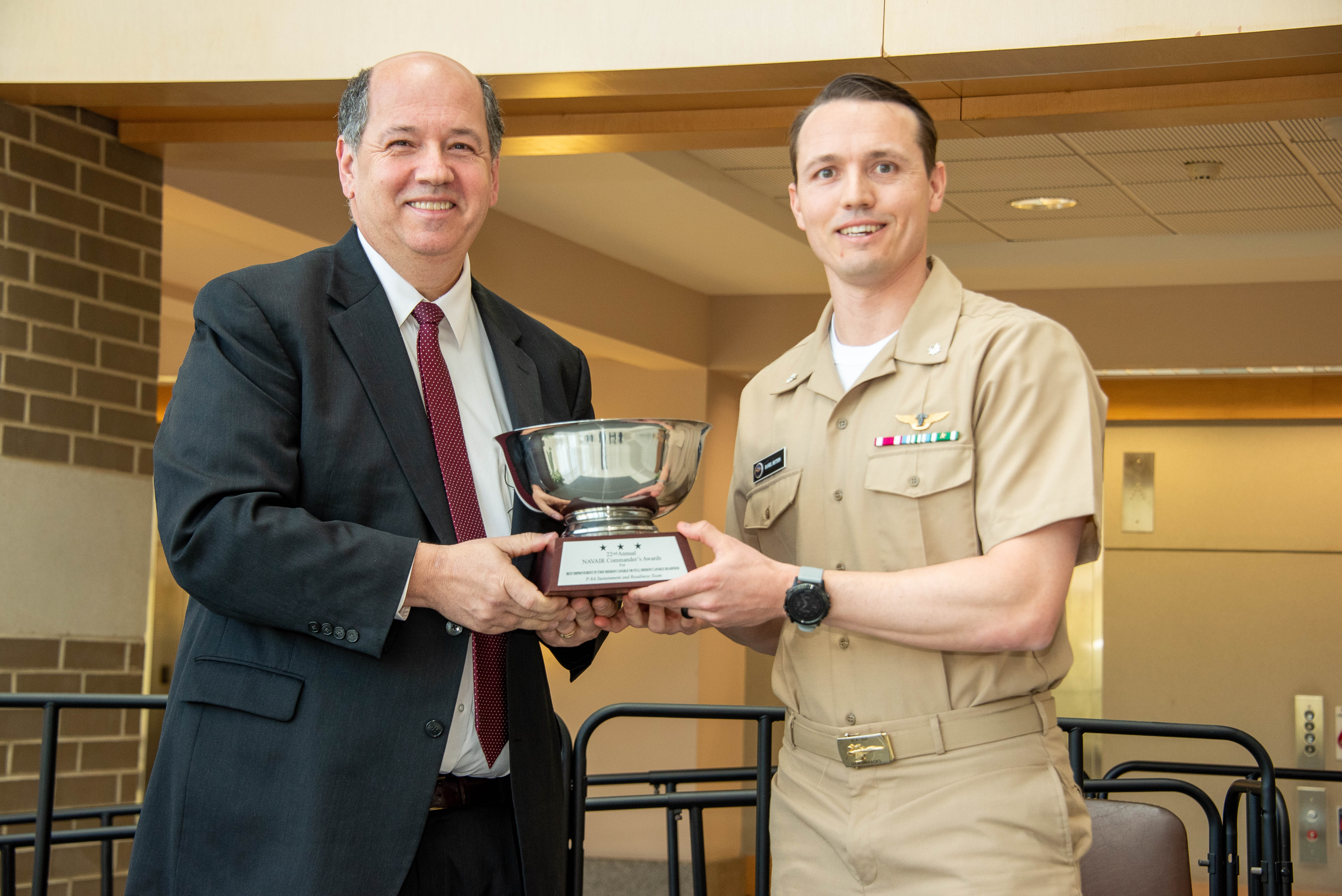 Cmdr. Dan Button accepts NAVAIR Commander's Award from Tom Rudowsky, NAVAIR deputy commander.