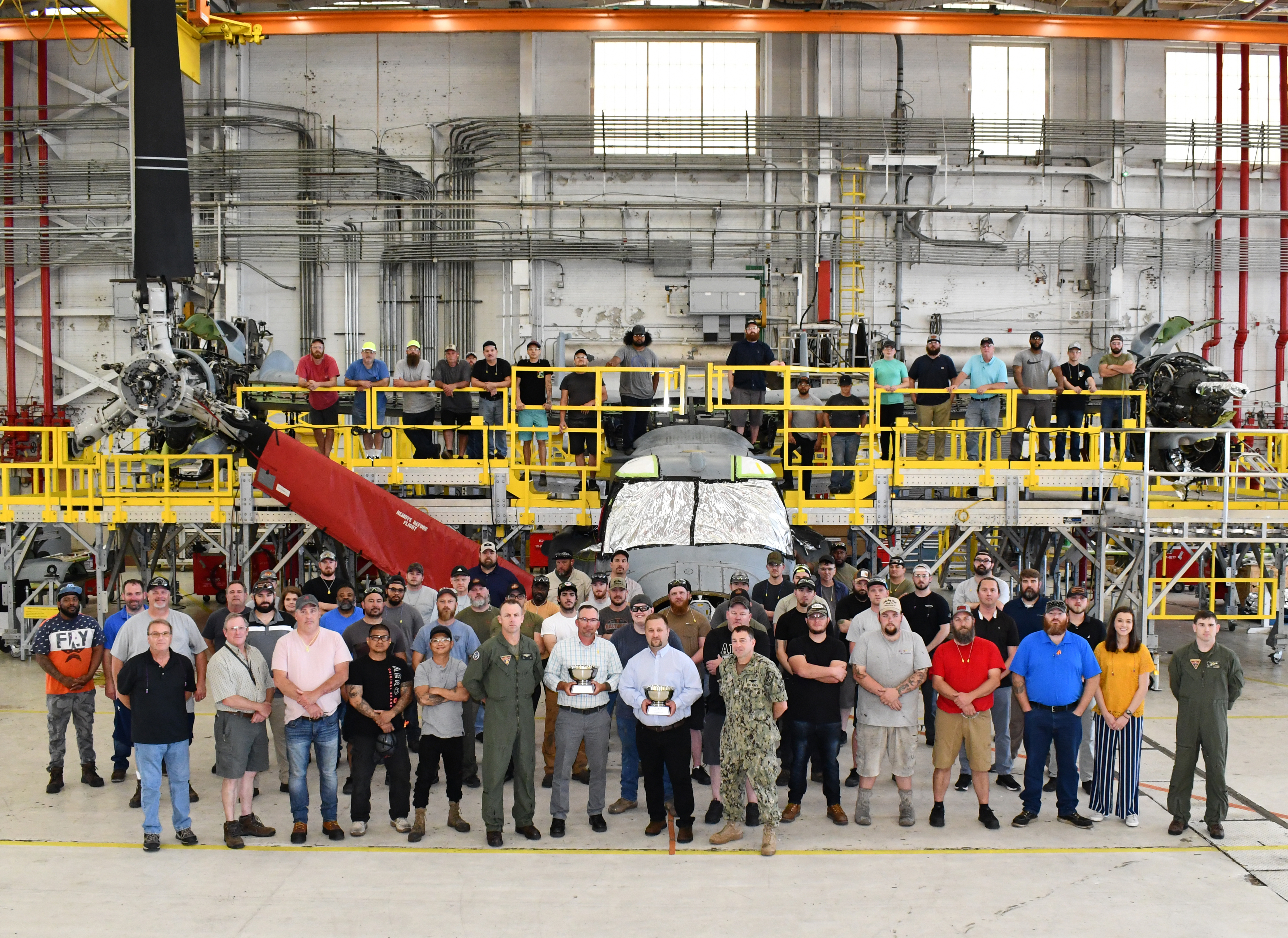 Group poses in front of V-22 aircraft