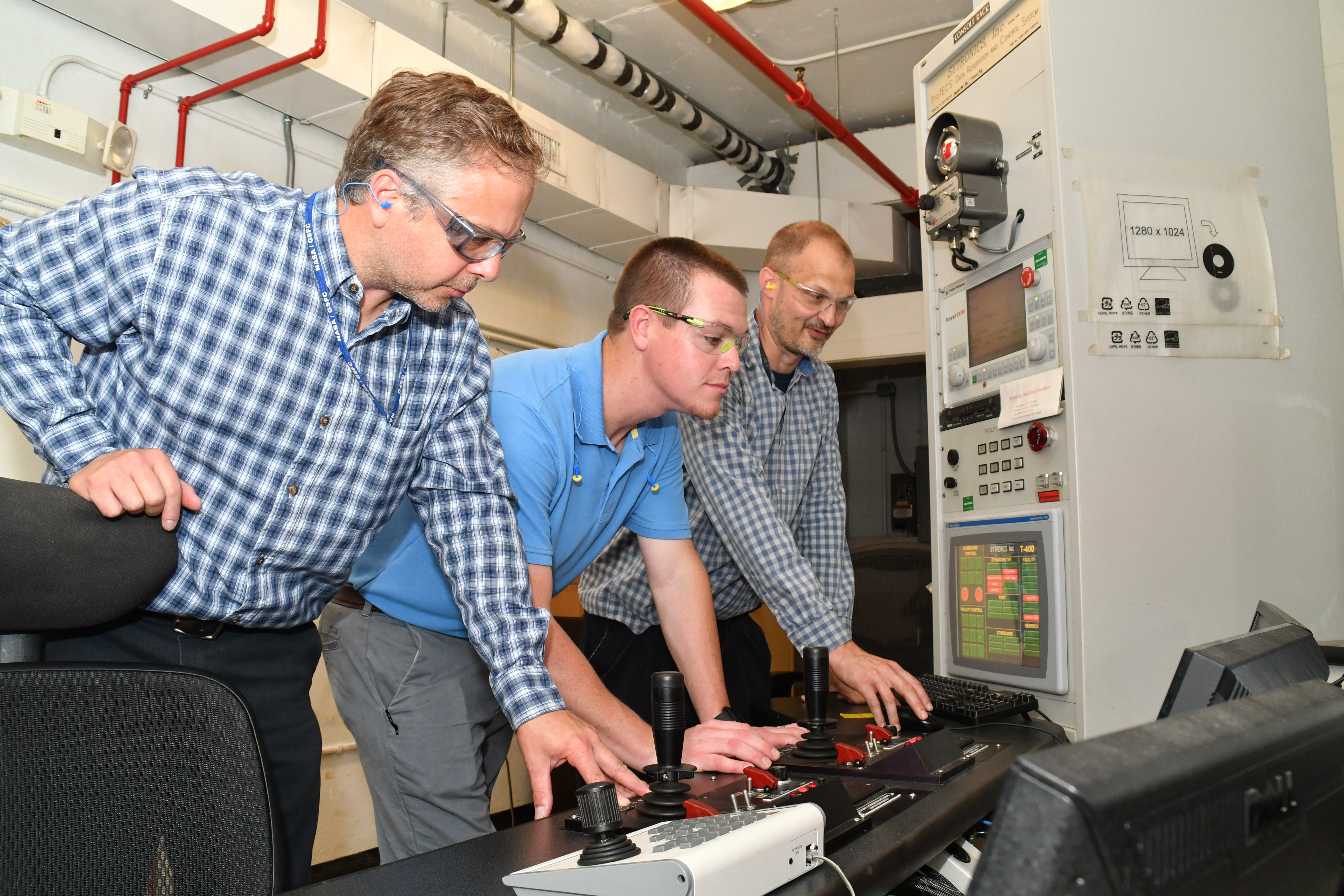 Three FRCE test equipment engineers observe software function on a jet engine test cell