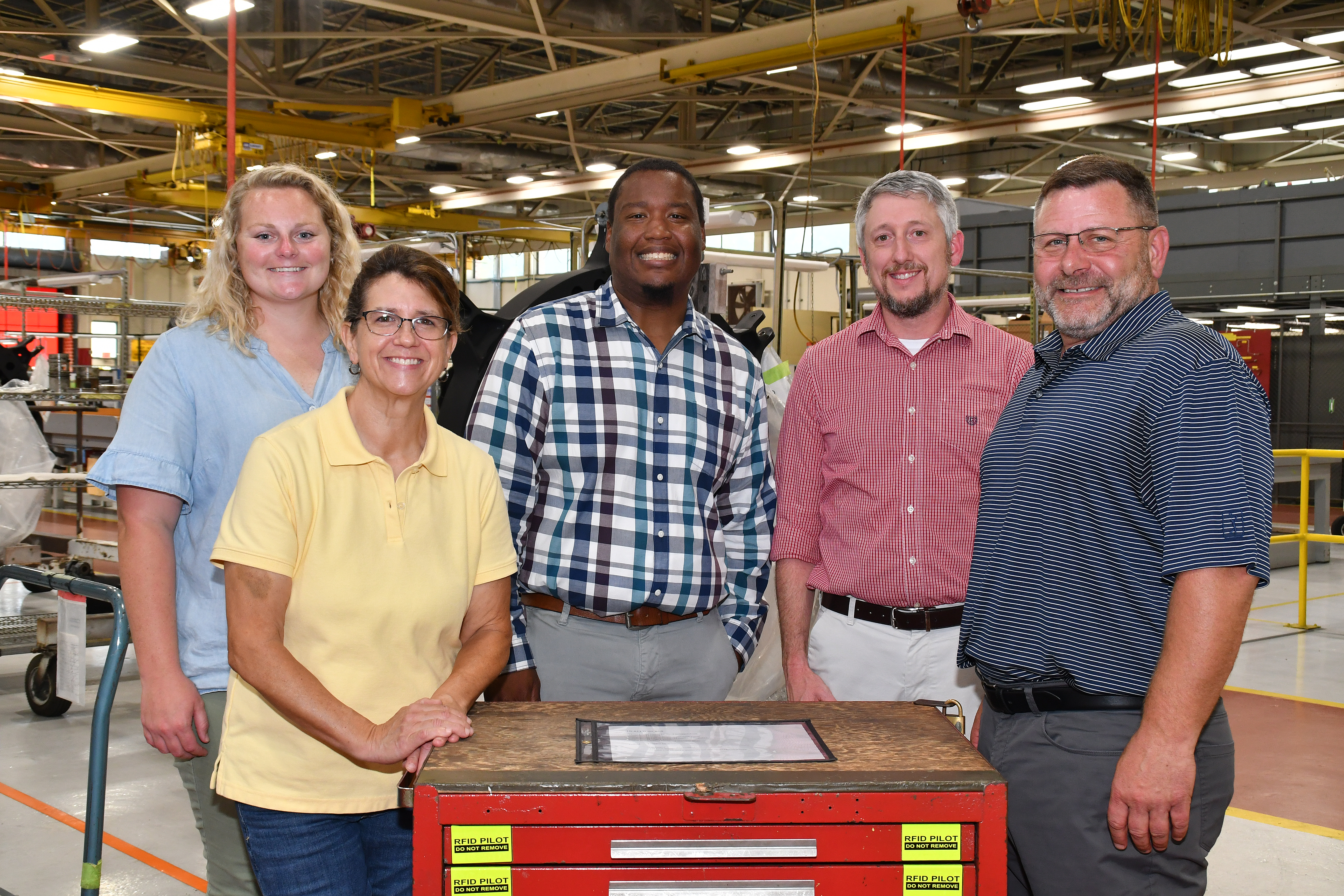 Members of the Fleet Readiness Center East (FRCE) digital tracking team pose for a group photo with a toolbox fitted with radio frequency identification (RFID) technology tags. The digital tracking team, composed of a wide range of subject matter experts from within the depot’s workforce, recently demonstrated a successful proof of concept for a digital tracking system incorporating RFID and other technology. FRCE officials say the system could boost efficiency and accountability within the FRCE workforce.