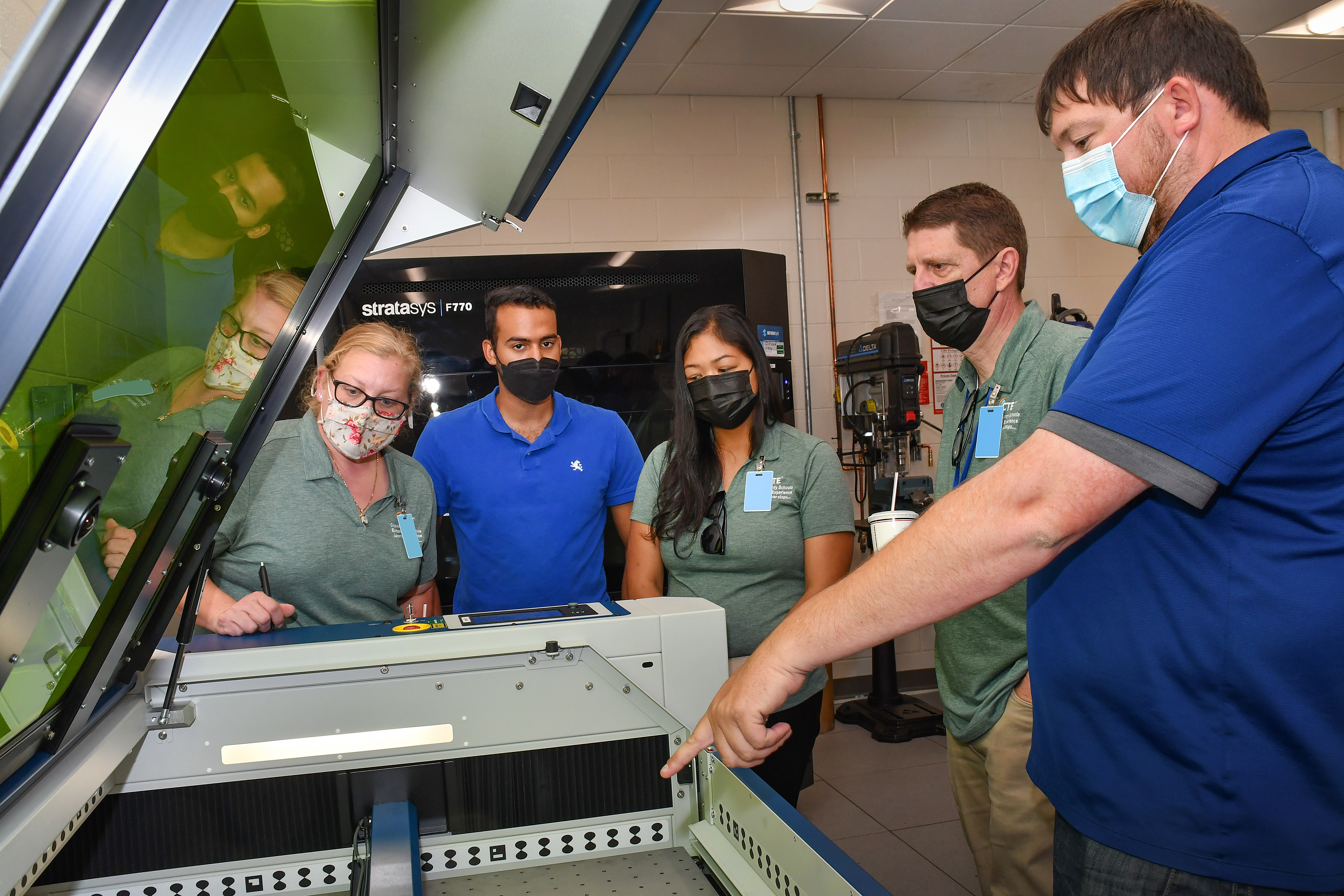 Fleet Readiness Center East (FRCE) Innovation Lead Engineer Randall Lewis, right, demonstrates the use of a 3D printer at the depot’s innovation lab to local educators during a four day externship program focused on preparing students for careers in industry. 