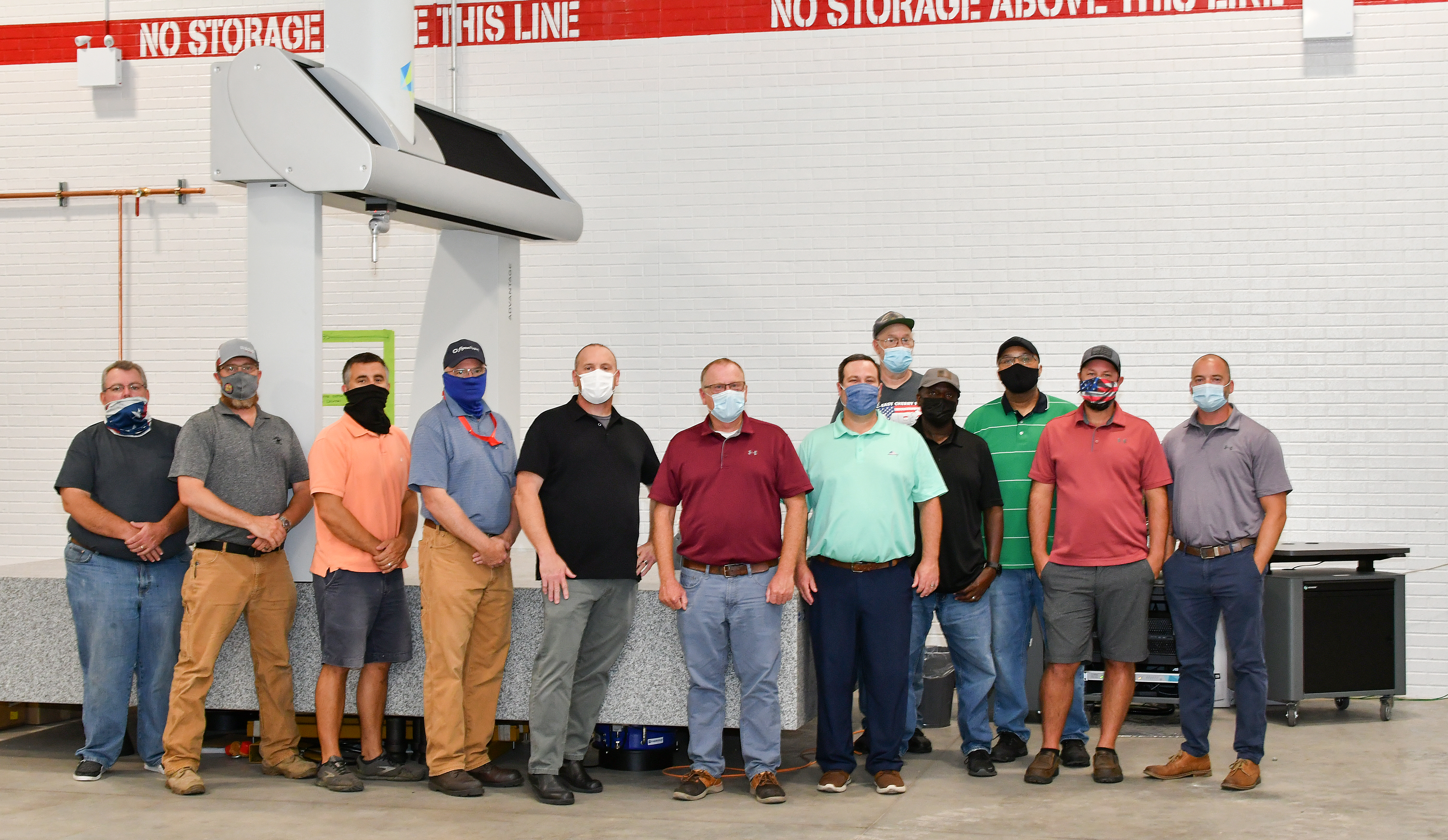Personnel from Fleet Readiness Center East’s (FRCE) Precision Measurement Center stand for a group photo in front of a newly acquired coordinate measuring machine (CMM). This machine is one of two new CMMs FRCE acquired capable of large-volume measurement. Depot officials say the additional machines will improve efficiency and reduce wait times caused by maintenance and equipment calibration. 