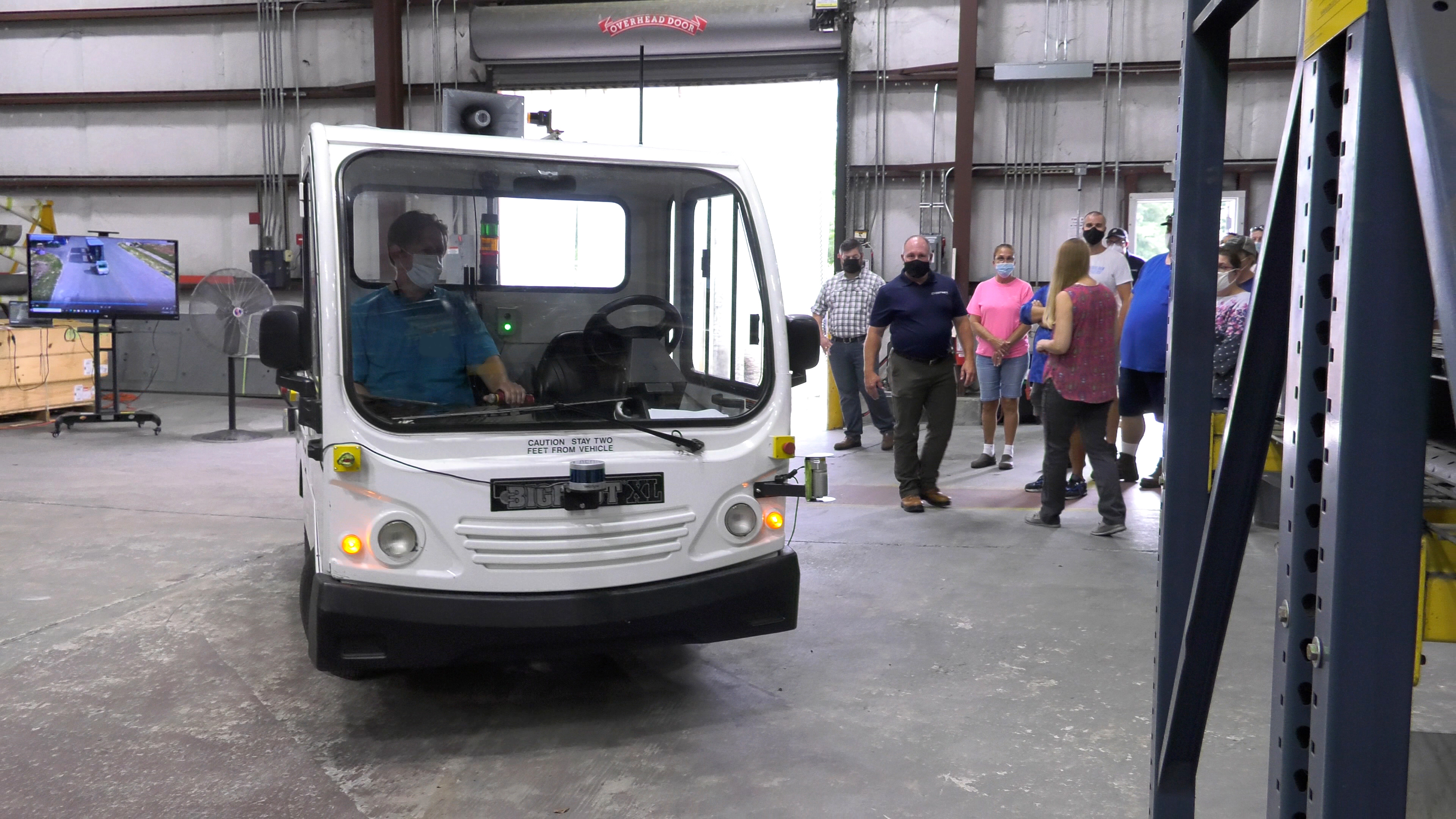 Driverless vehicle turns down aisle in warehouse