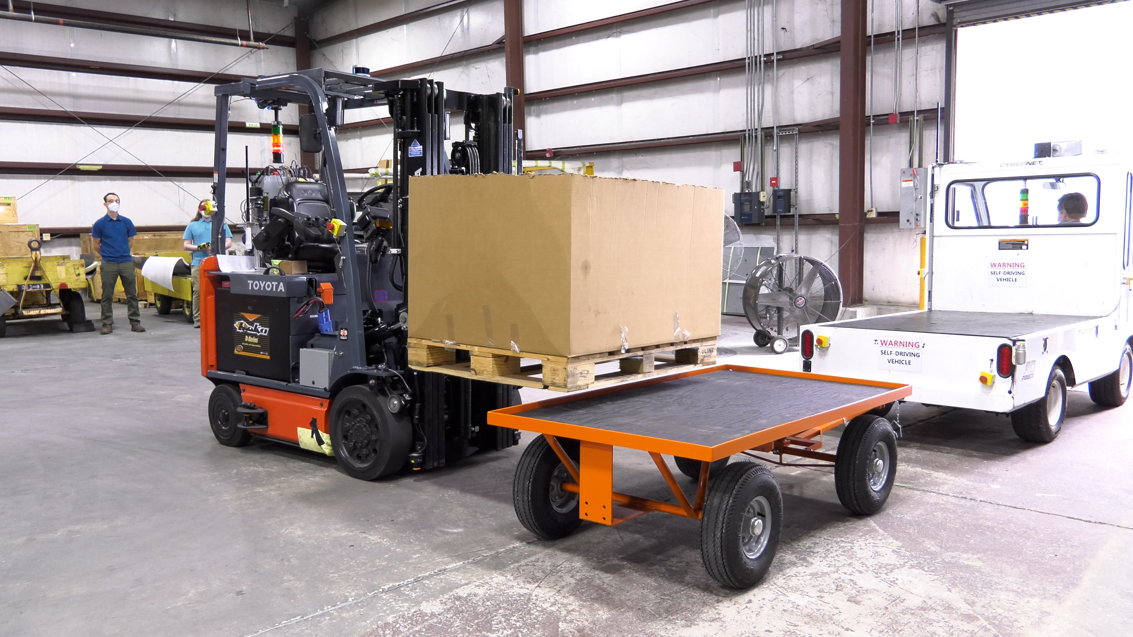 Forklift loads crate on trailer
