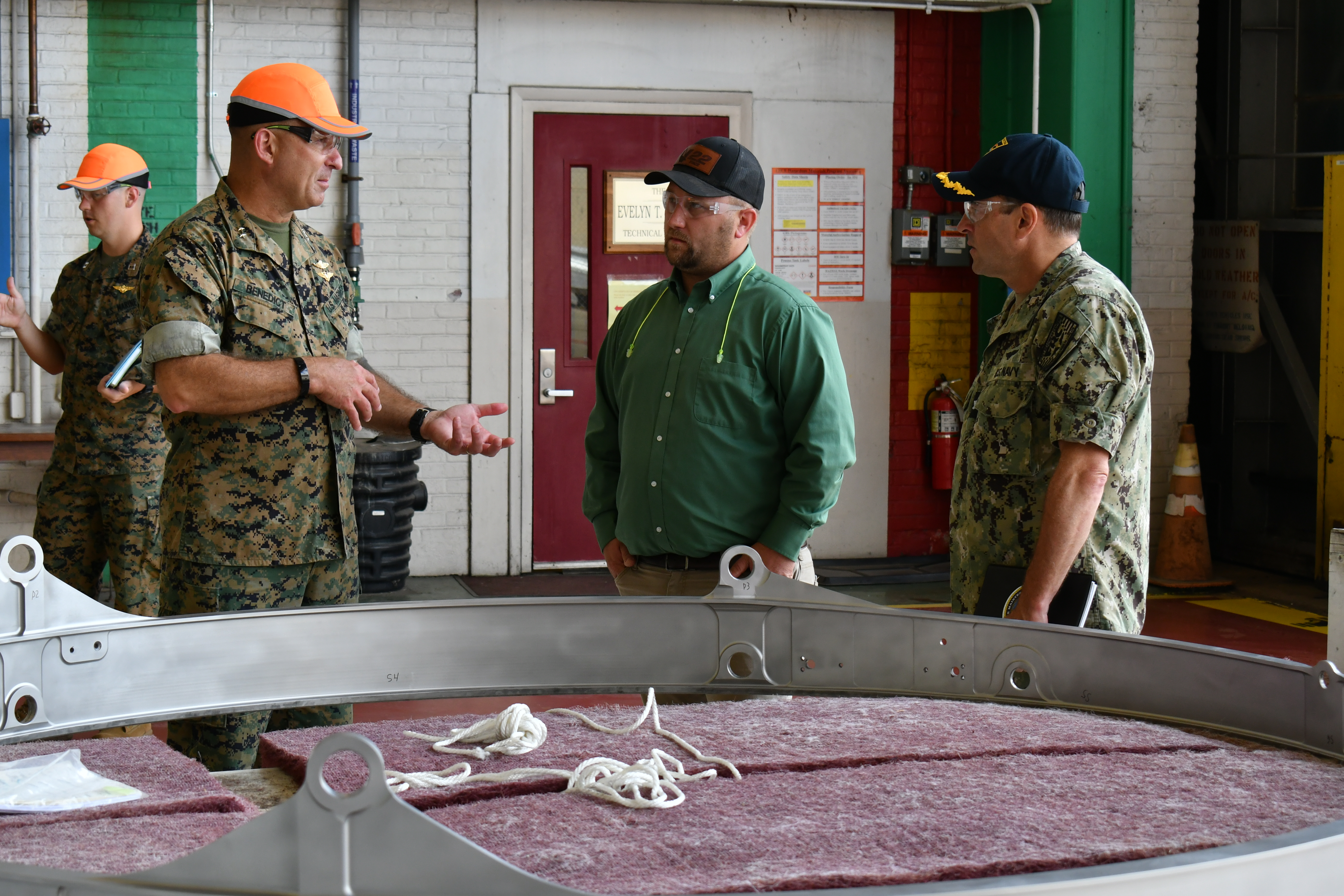 Maj. Gen. Scott F. Benedict, commanding general of 2nd Marine Aircraft Wing (MAW), left, discusses MV-22 stow rings with  Fleet Readiness Center East (FRCE) Commanding Officer Capt. James Belmont  and FRCE V-22 Branch Head Andrew Rock during an Aug. 30 tour of the depot by 2nd MAW leadership. 