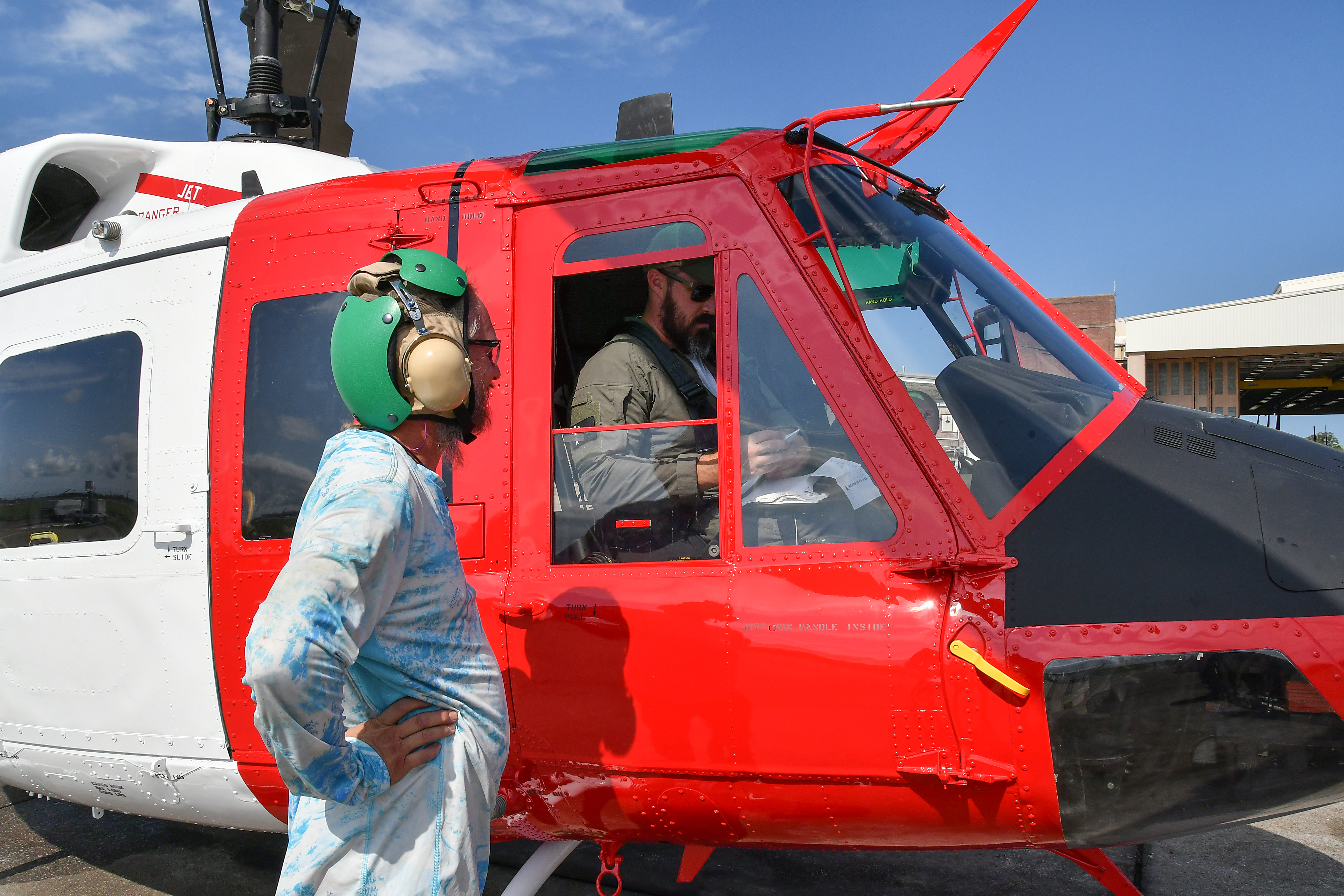Aircraft maintainer and pilot discuss performance of UH-1N helicopter after functional check flight