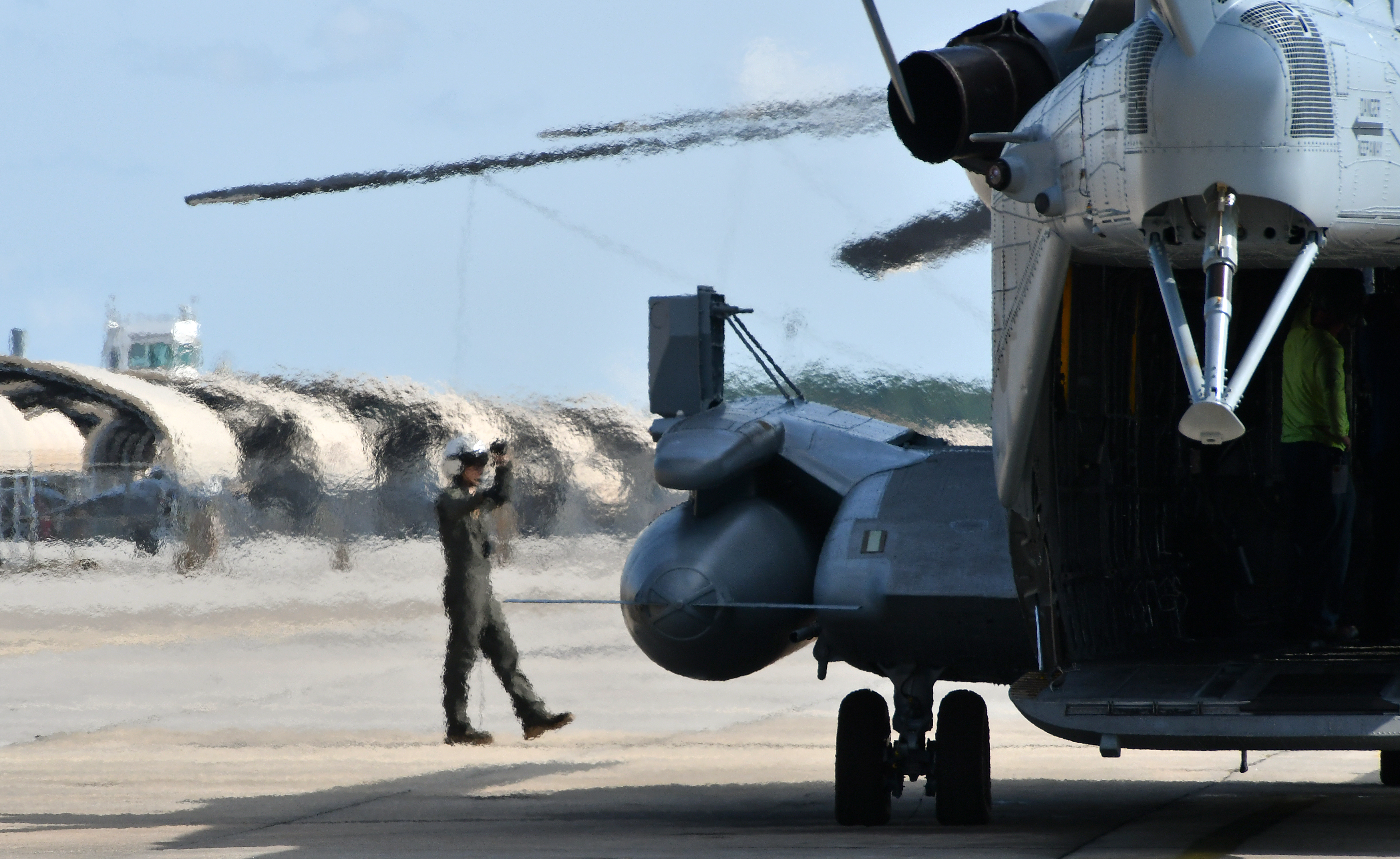 Cpl. Devon Schoff, a CH-53 crew chief at Fleet Readiness Center East (FRCE), signals to the pilot as the aircrew prepares to return a recently overhauled CH-53 helicopter to the fleet. 