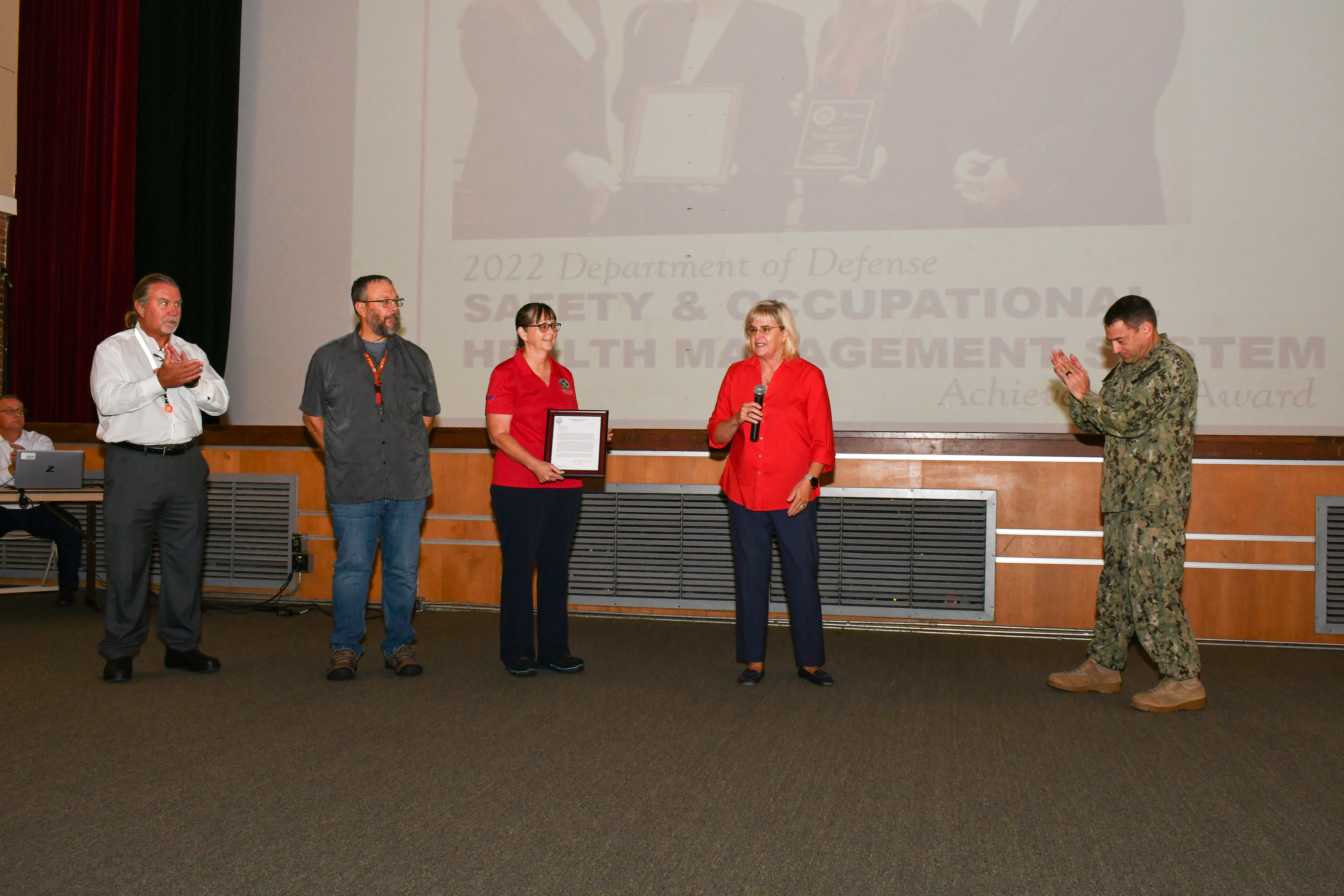 Fleet Readiness Center East (FRCE) Commanding Officer Capt. James M. Belmont and FRCE Compliance and Quality Department Head Amy Morgan congratulate members of the depot’s safety team for their recognition by the North Carolina Department of Labor Safety Awards Program. 