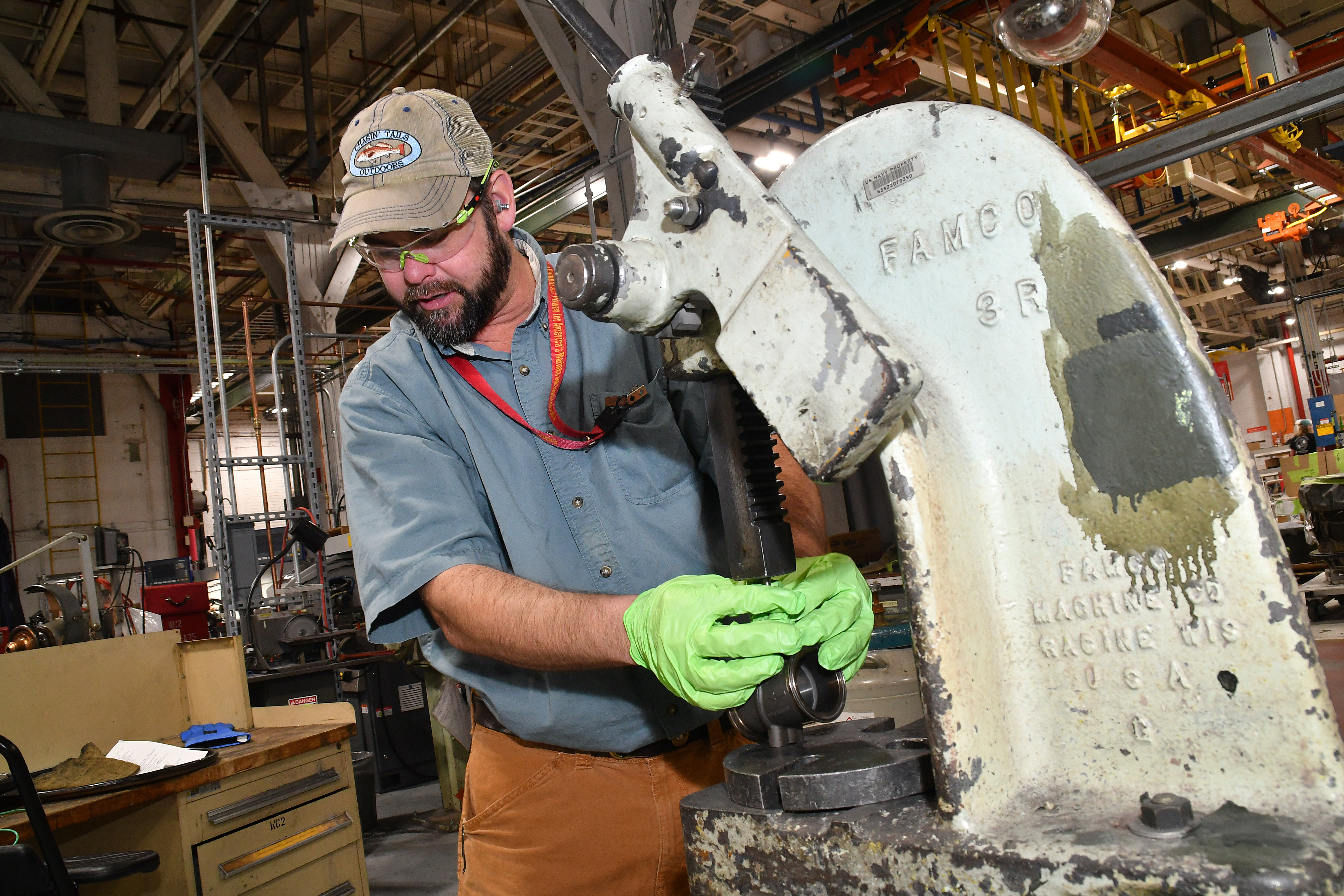 Jeremy Pedersen, machinist at Fleet Readiness Center East’s Repair Machine Shop, utilizes a press while working on an aircraft component. The Repair Machine Shop is made up of 22 work centers where 70 highly trained machinists recondition everything from helicopter transmissions to jet engine components. 