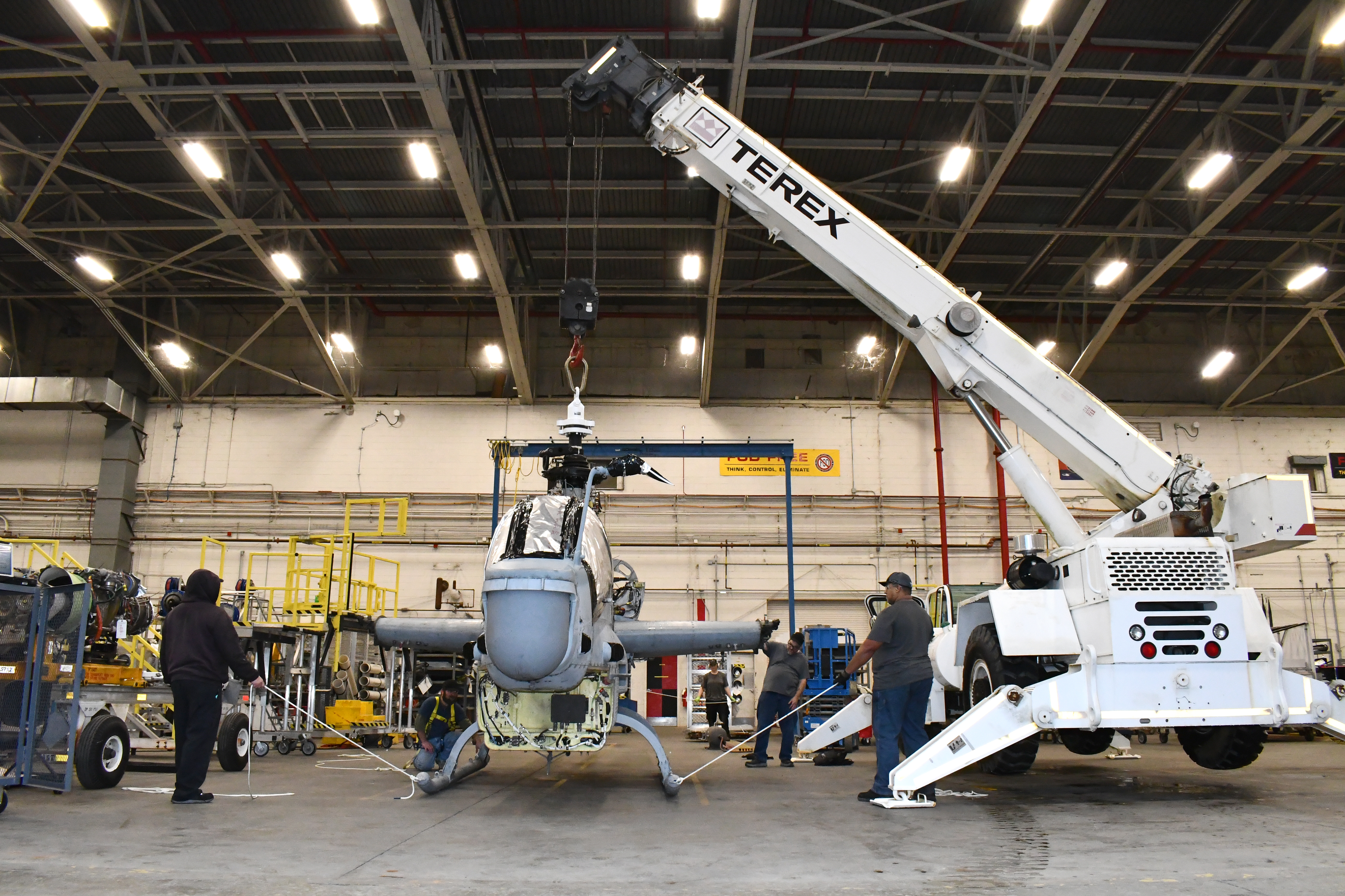 Workers prepare AH-1Z airframe for lift by crane