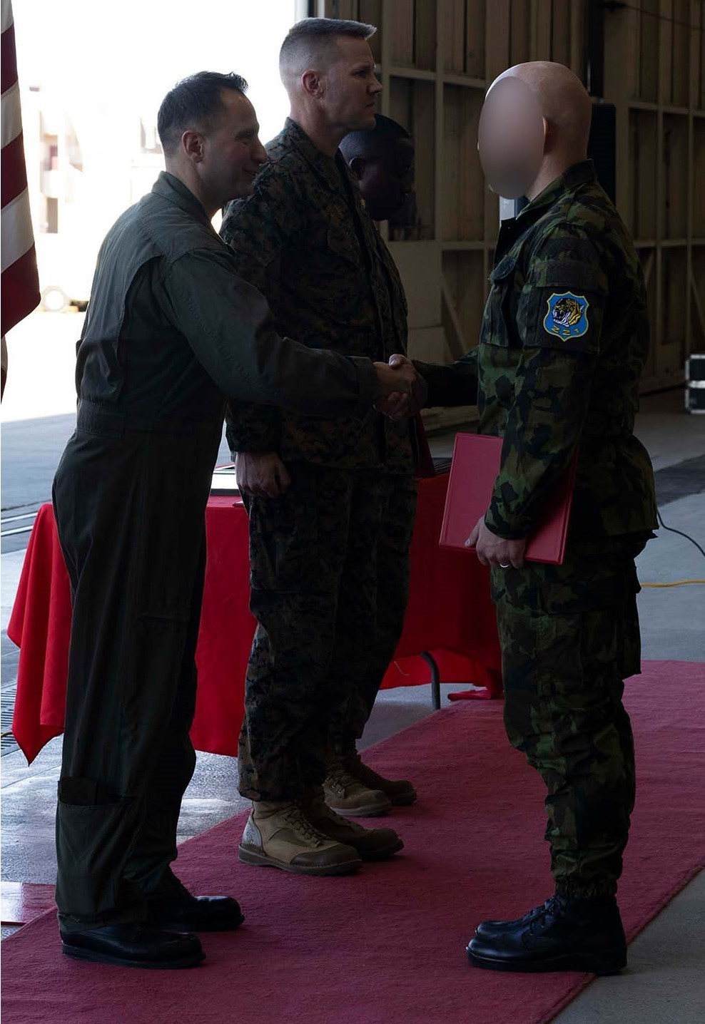 A Czech Air Force crew chief accepts his graduation certificate from U.S. Marine Corps Col. Vasilios E. Pappas